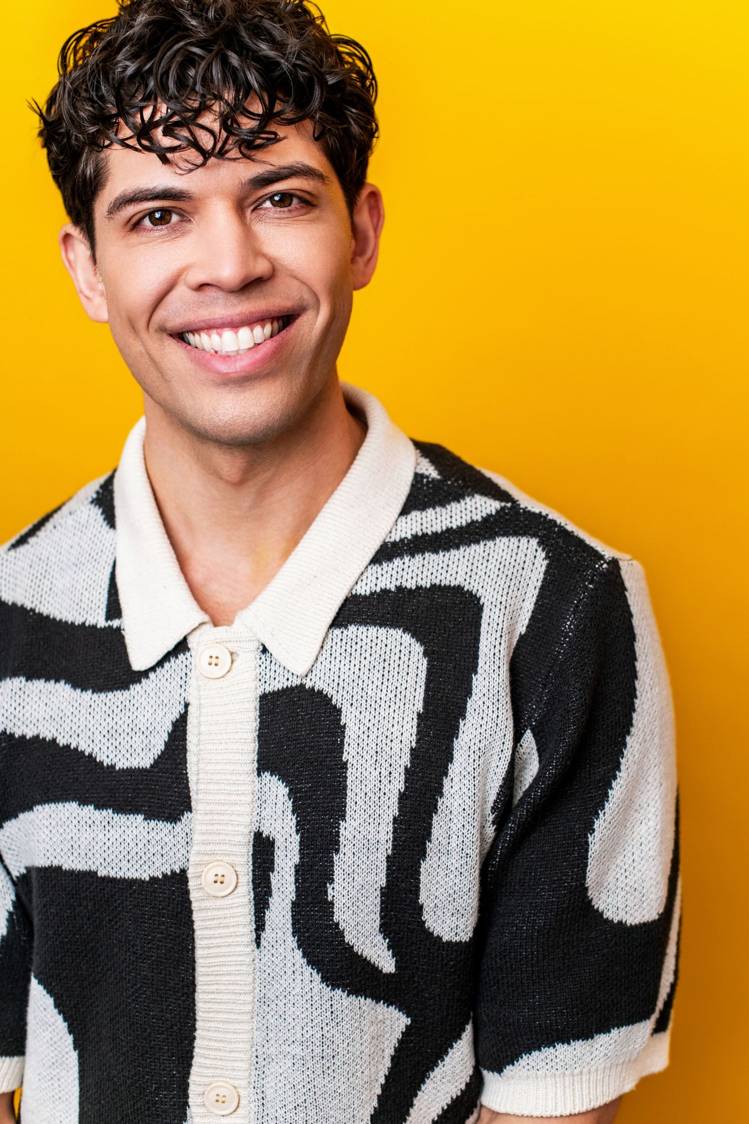 Los Angeles actor headshot featuring a relaxed, confident expression on a bold yellow studio background