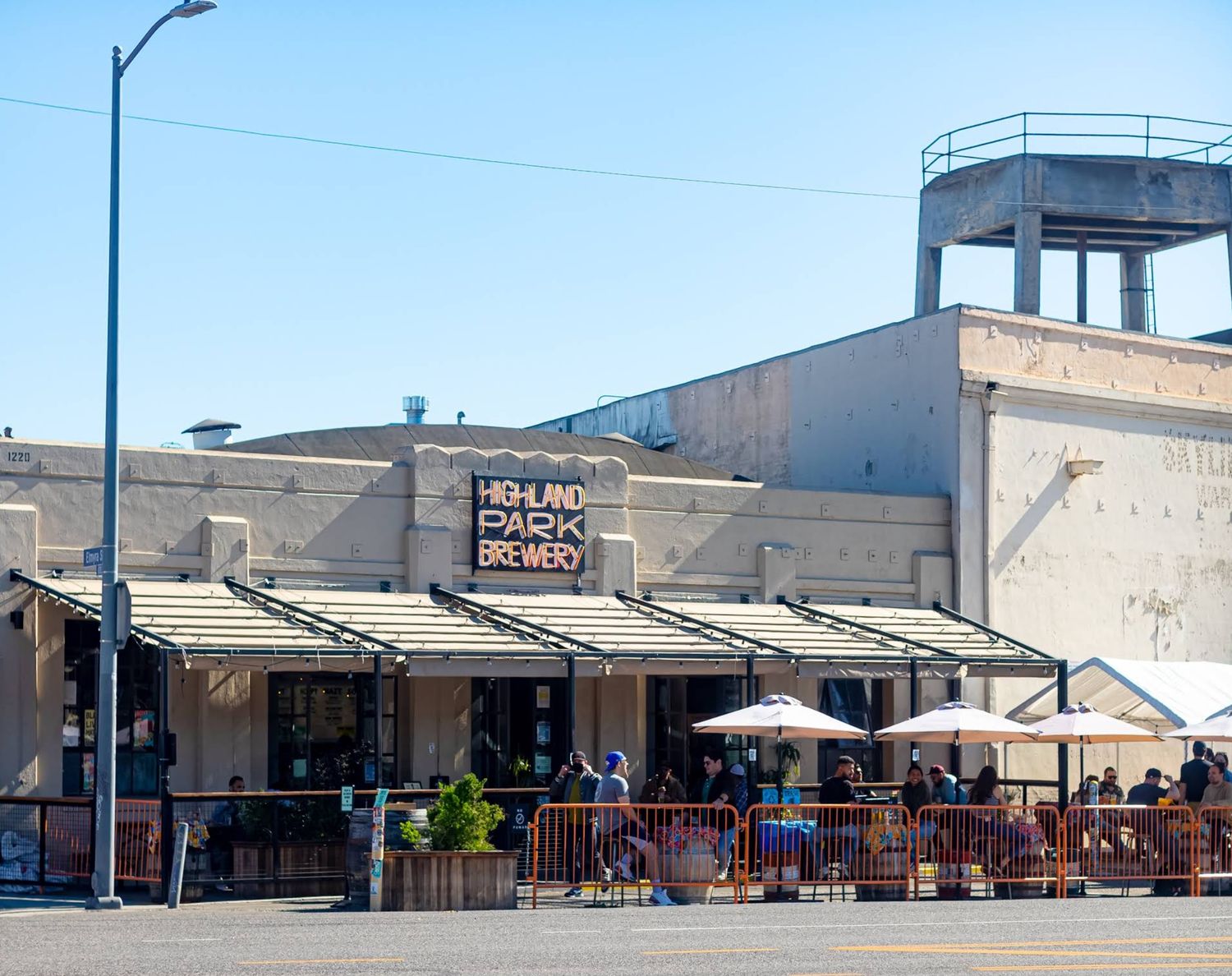 Exterior of Highland Park Brewery in Los Angeles with a large outdoor patio and seating.