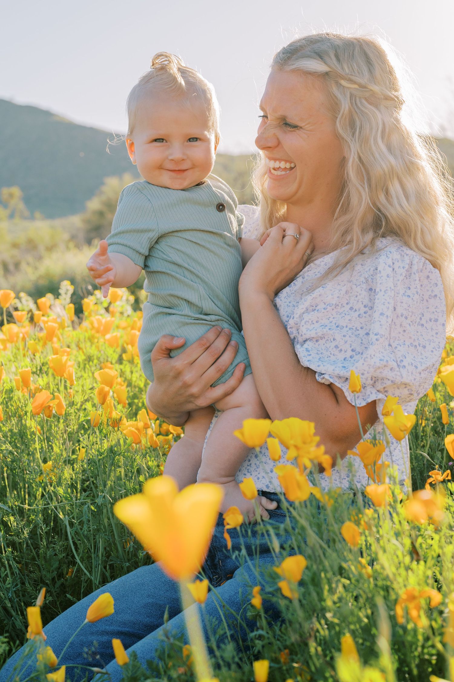 Family photo in a vibrant yellow wildflower field on a sunny afternoon with mountains in the background. Phoenix Arizona family photographer
