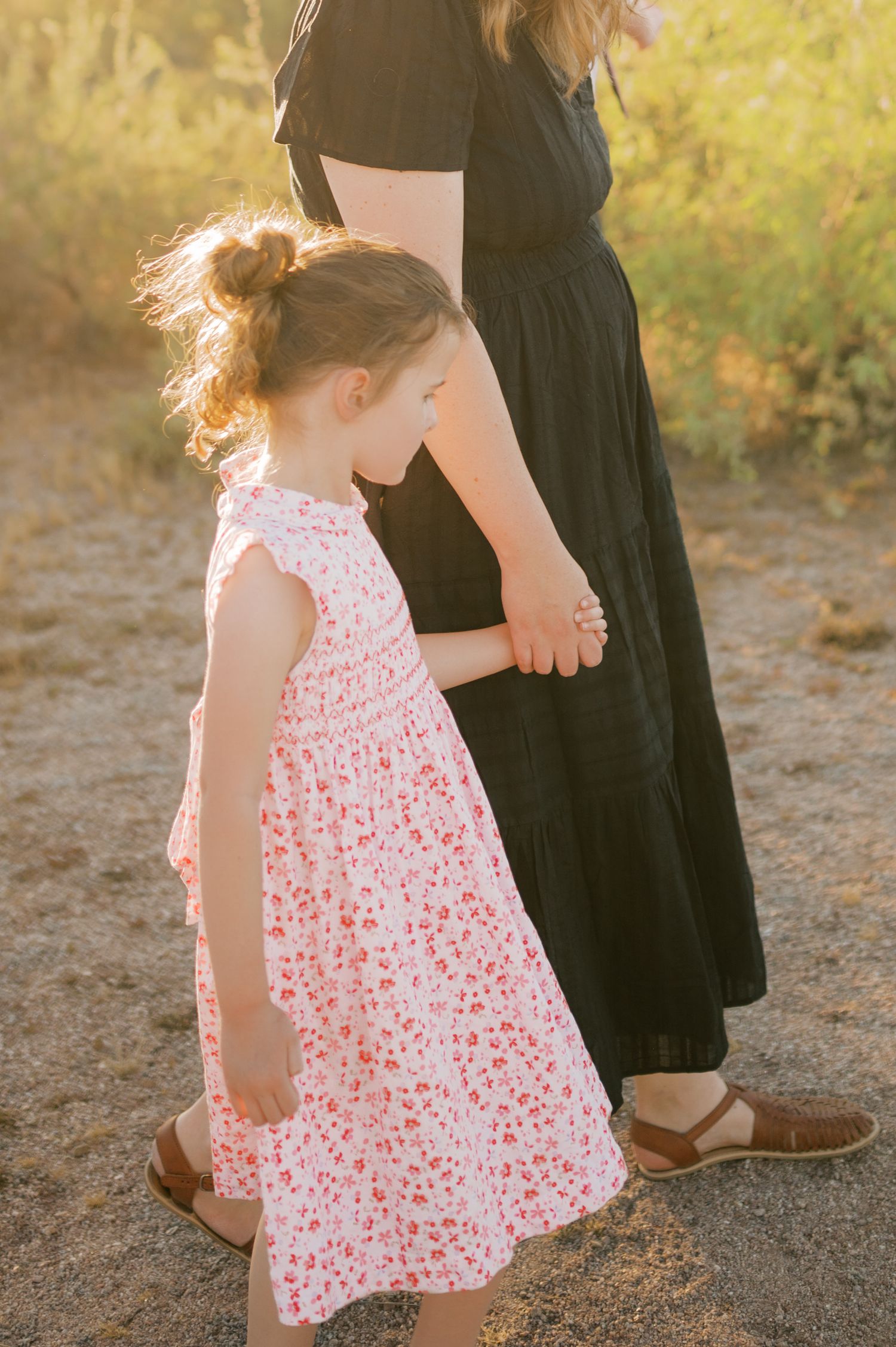 Siblings holding hands walking through desert in Gilbert Arizona