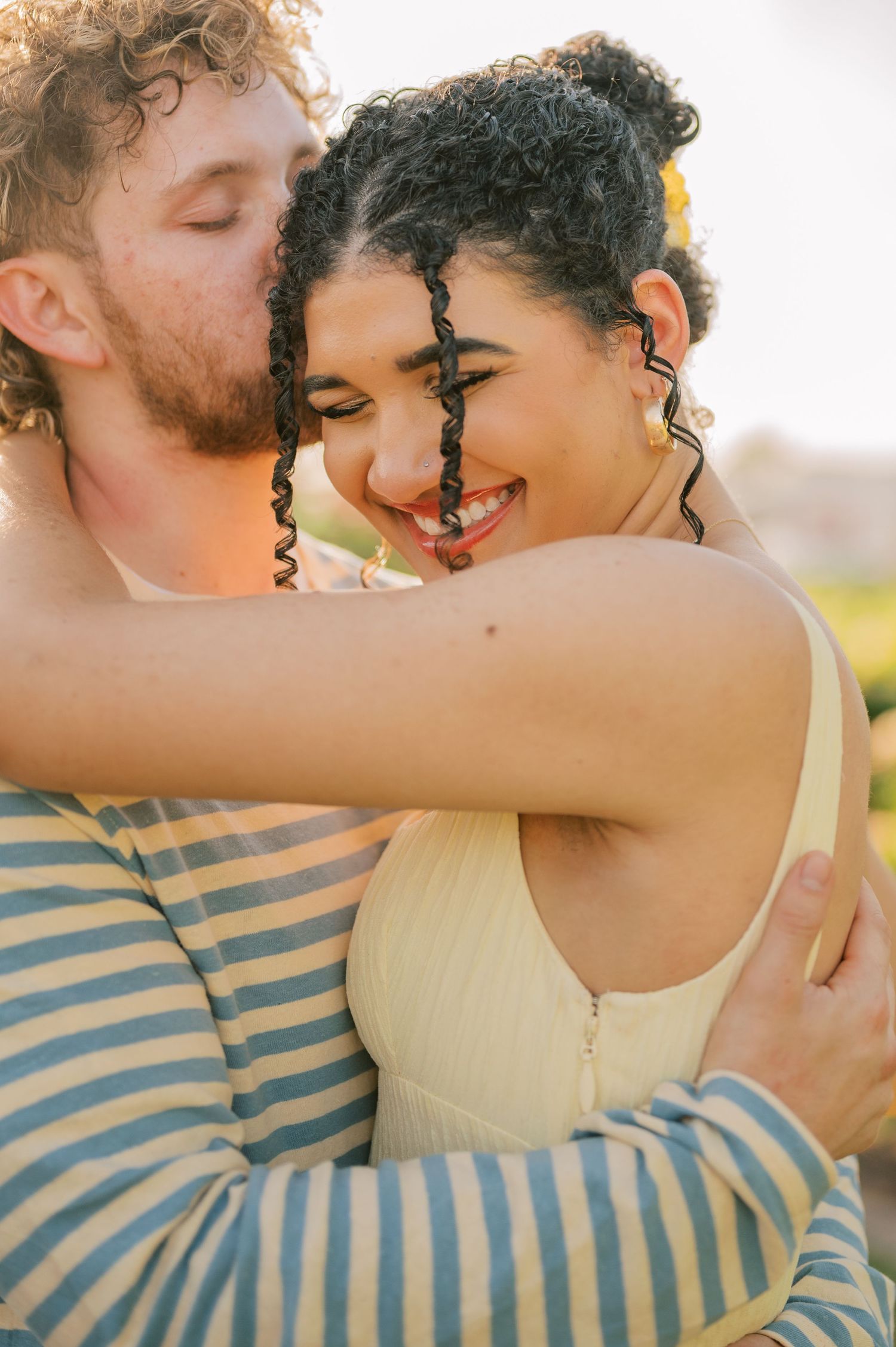 Couple embracing in rose garden during romantic sunset session