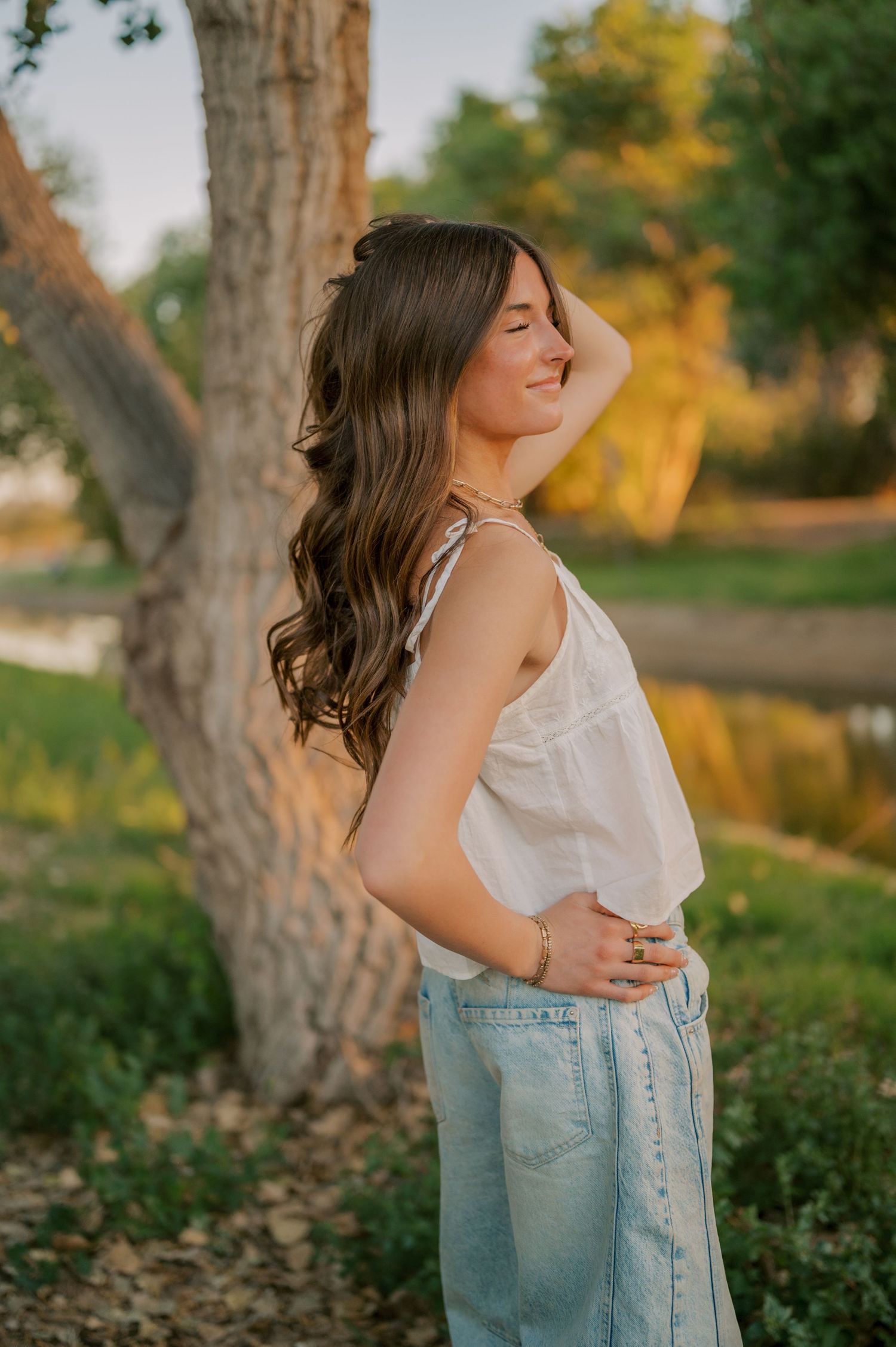 Natural senior photos in a dreamy tree-lined canal setting at golden hour