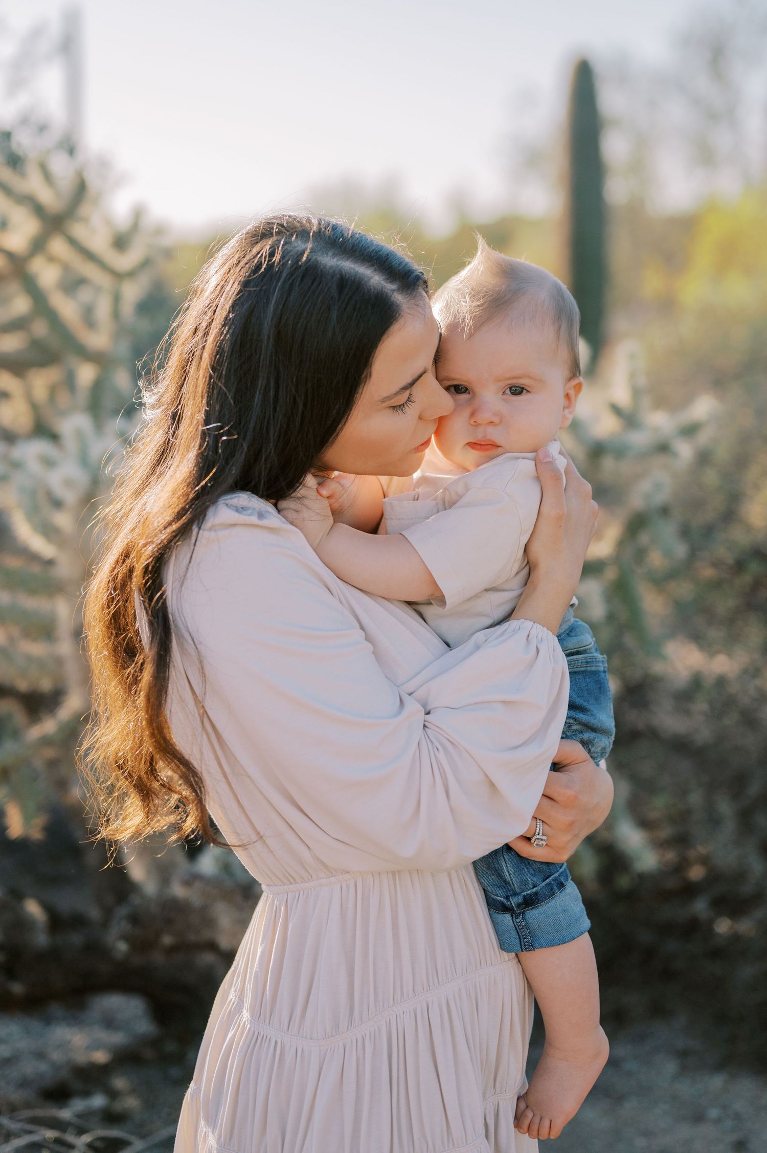 A tender moment between parent and child captured in a series of outdoor portrait photographs against a stone wall.