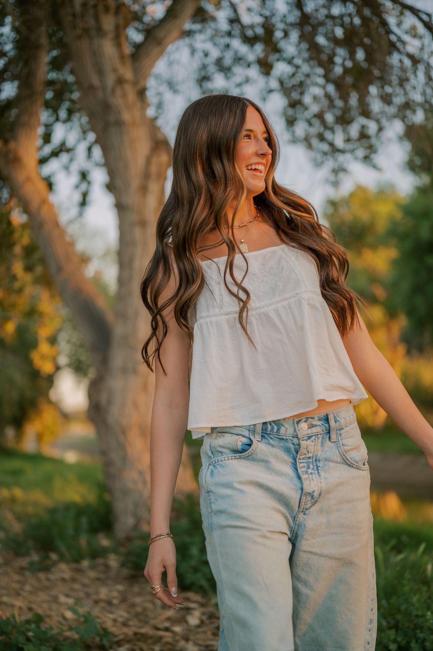 High school senior portrait in a tree-lined canal with soft, whimsical light