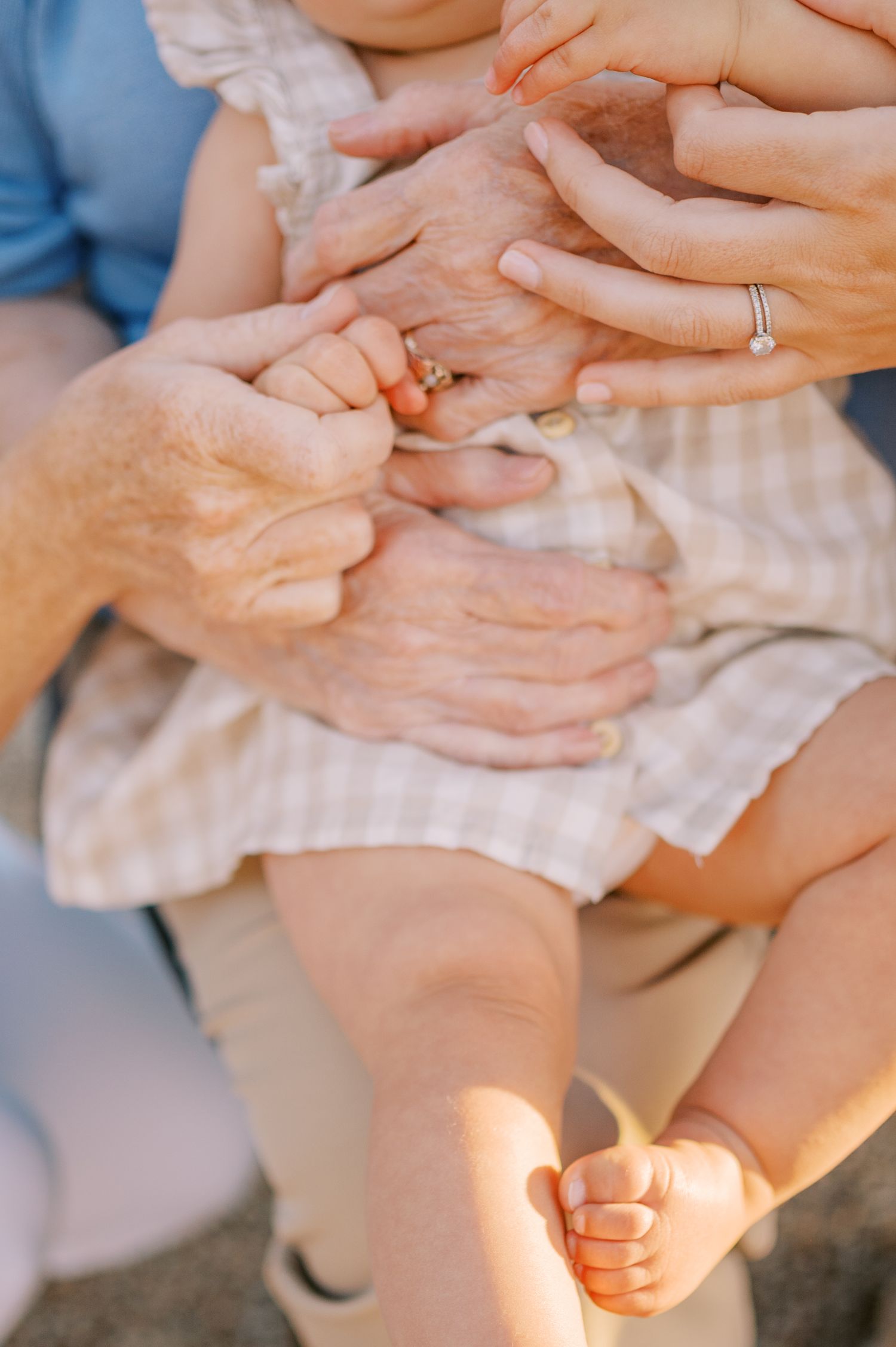 Close-up view of hands gently massaging a baby's feet during an infant massage session. Phoenix Arizona family photographer.
