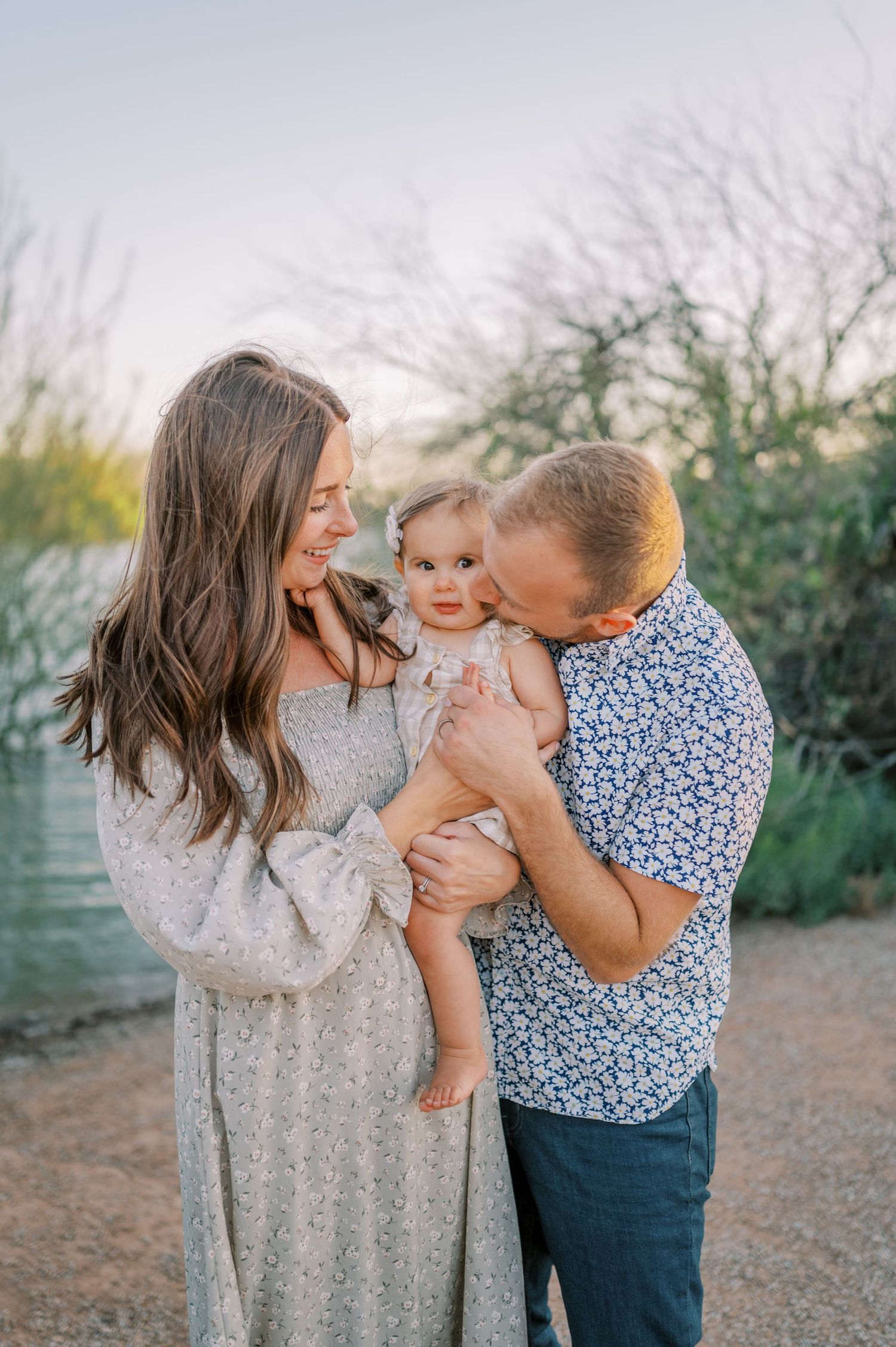 A loving family shares a tender moment together outdoors on a sunny day in a natural desert setting. Phoenix Arizona family photographer.