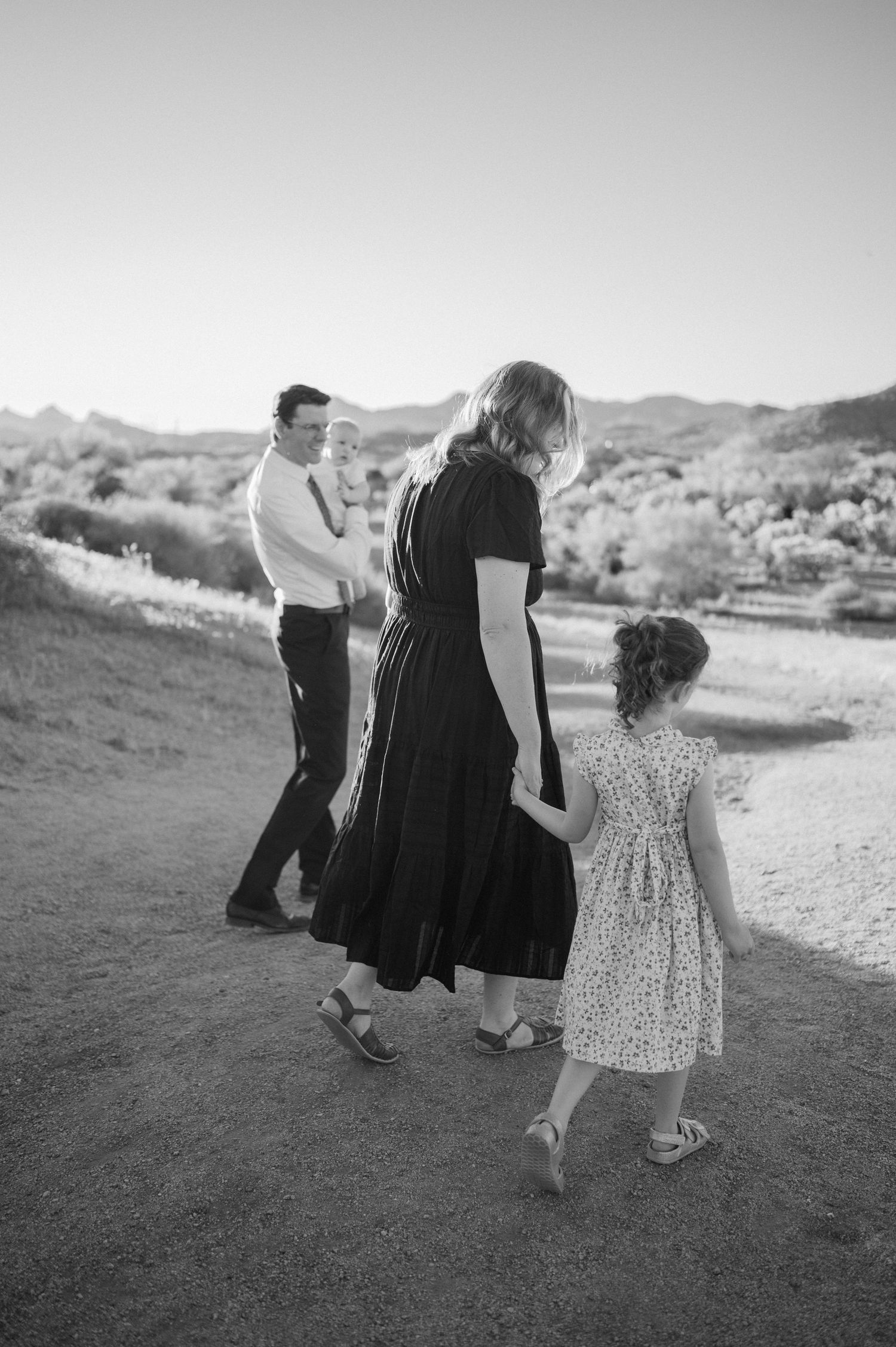 Black and white family photo of parents and two children walking in the Arizona desert