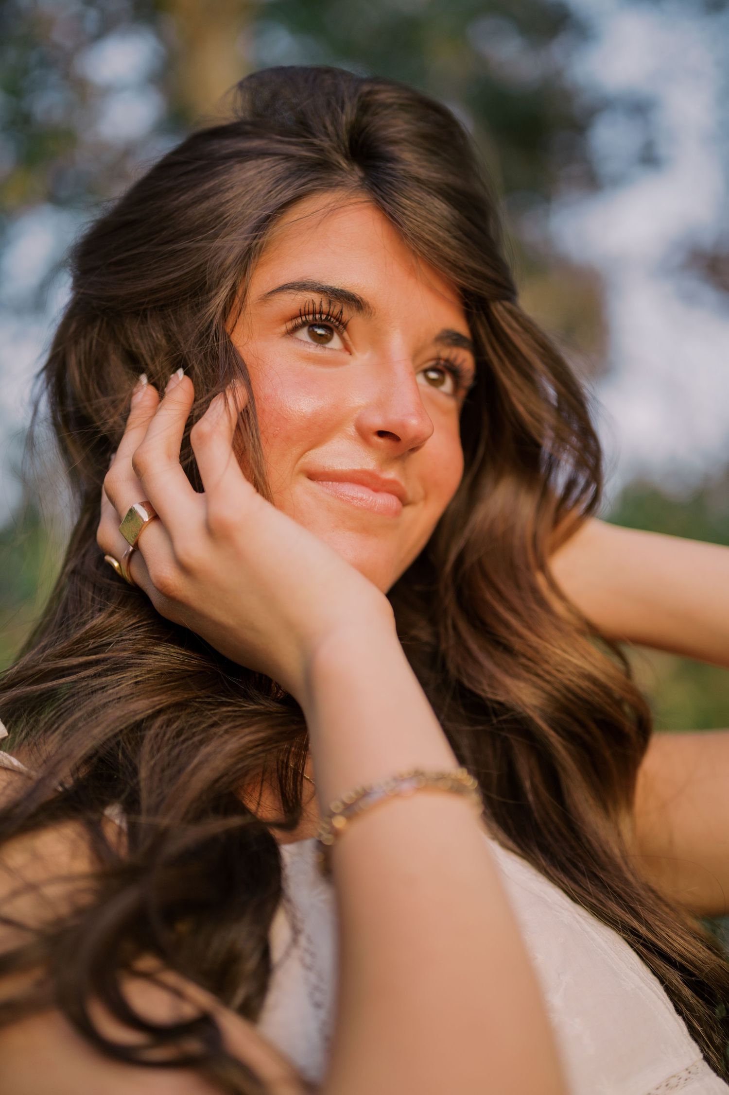 Outdoor senior photography session with soft greenery and water reflections