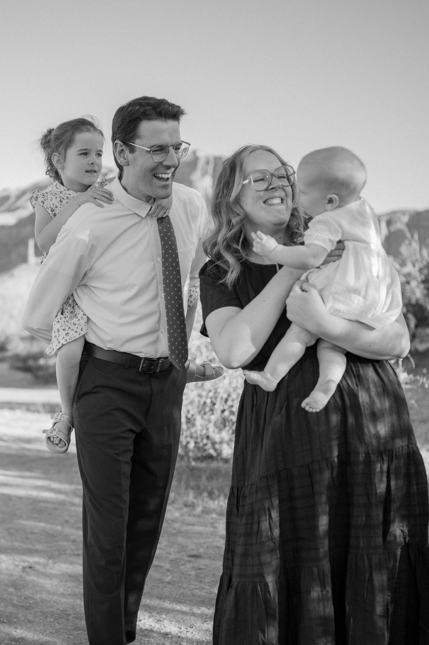 Family embracing with mountain backdrop in Gilbert AZ