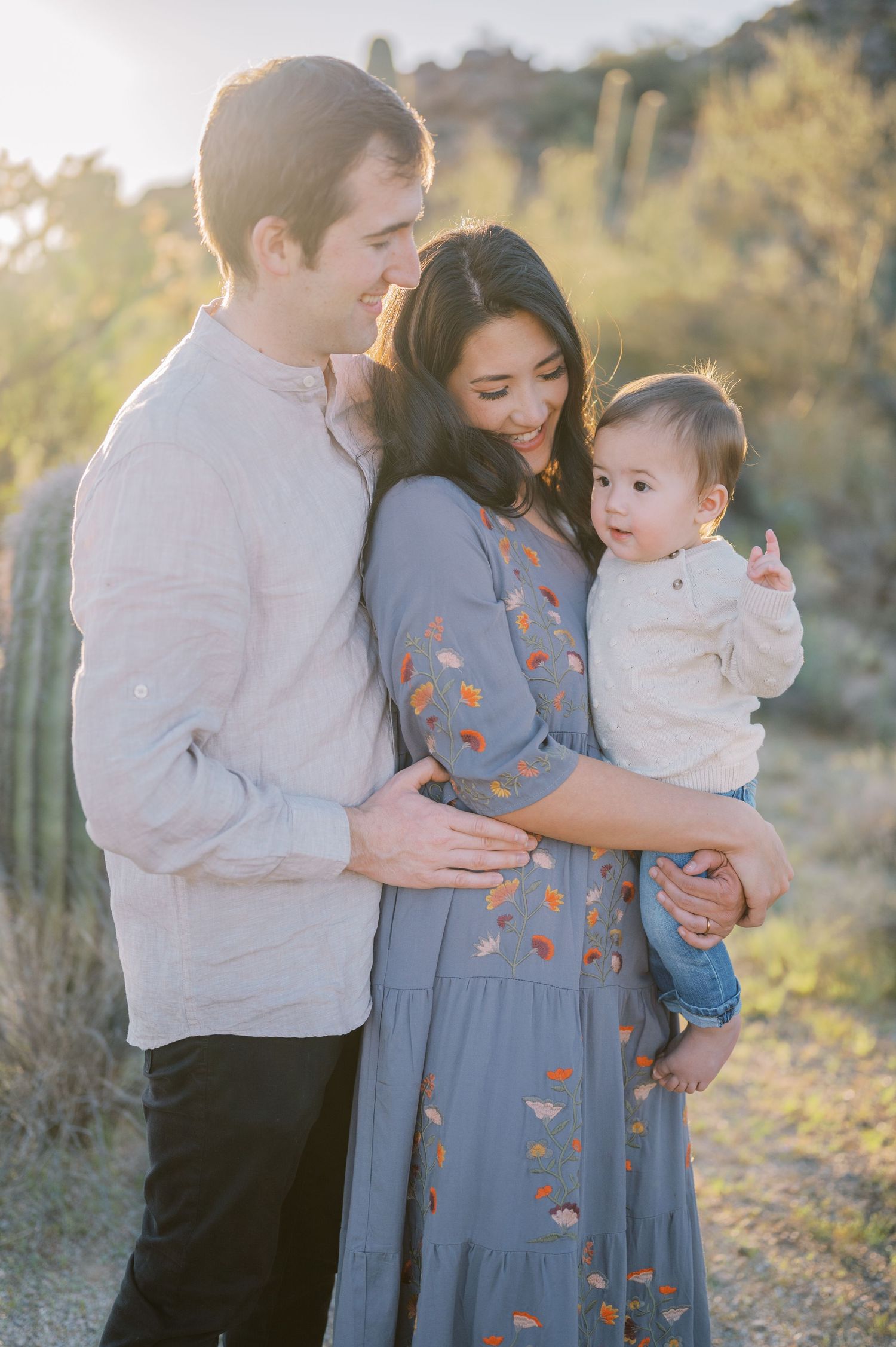 A family shares tender moments together in an outdoor setting during golden hour. Phoenix Arizona family photographer.