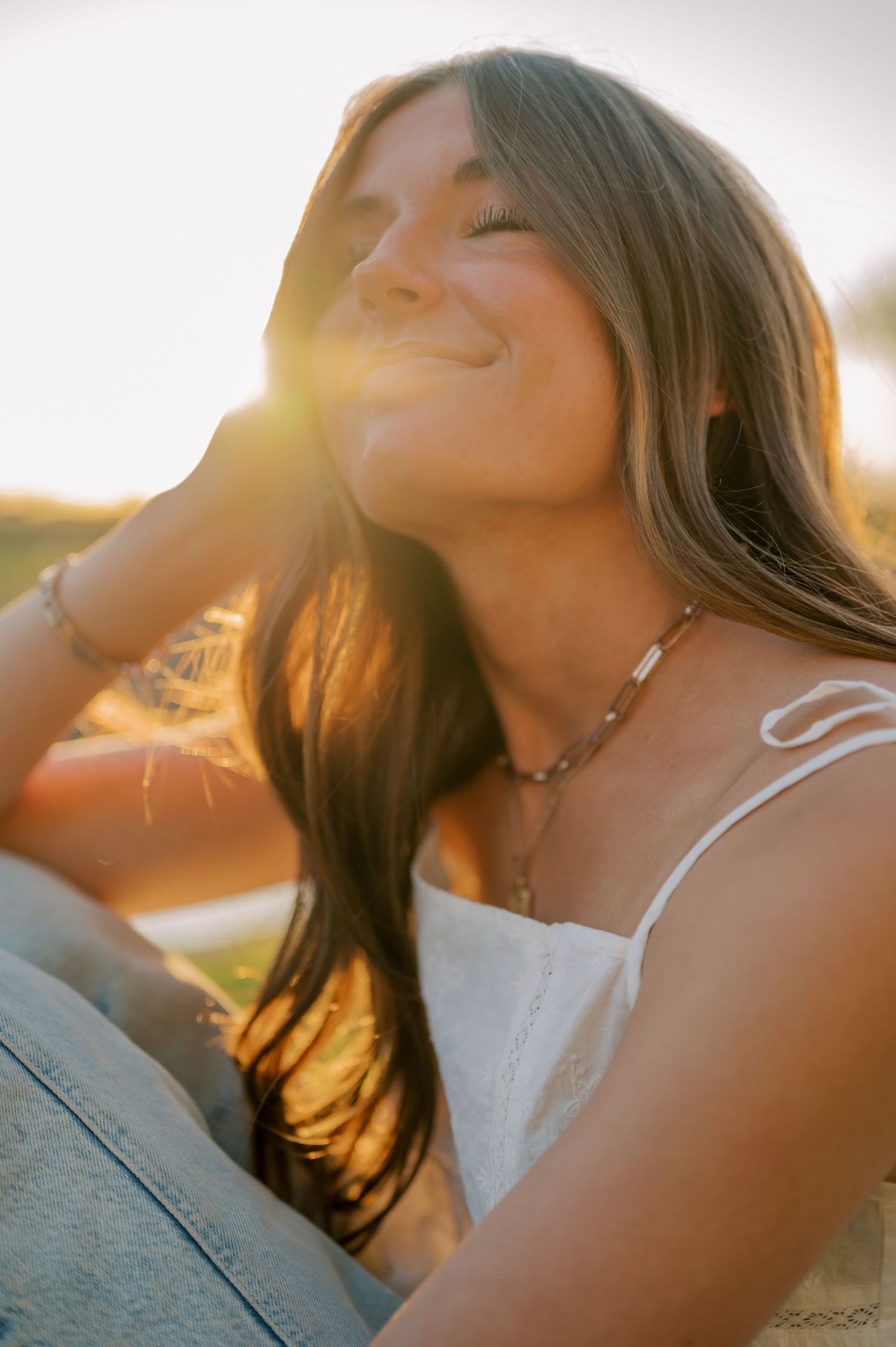 Senior portrait with sun flare through trees in a lush canal setting