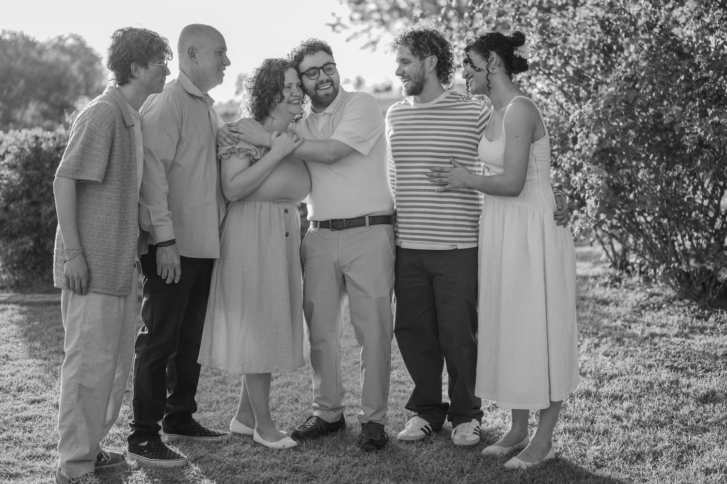 Romantic family photos surrounded by pink and red roses in full bloom in gilbert arizona