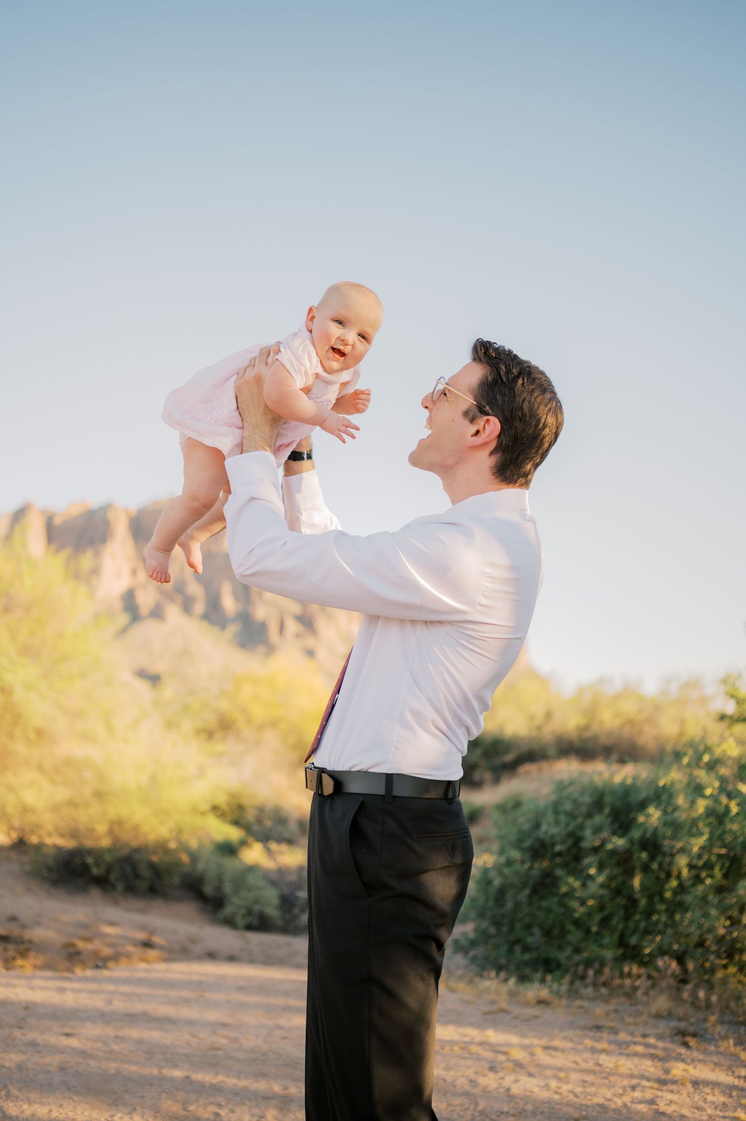 Father lifting child with superstition mountains in background Phoenix Arizona family session