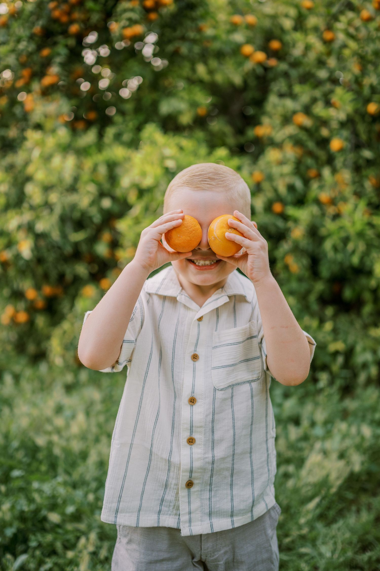 Milestone photographer in Phoenix Arizona. Boy playing with oranges.