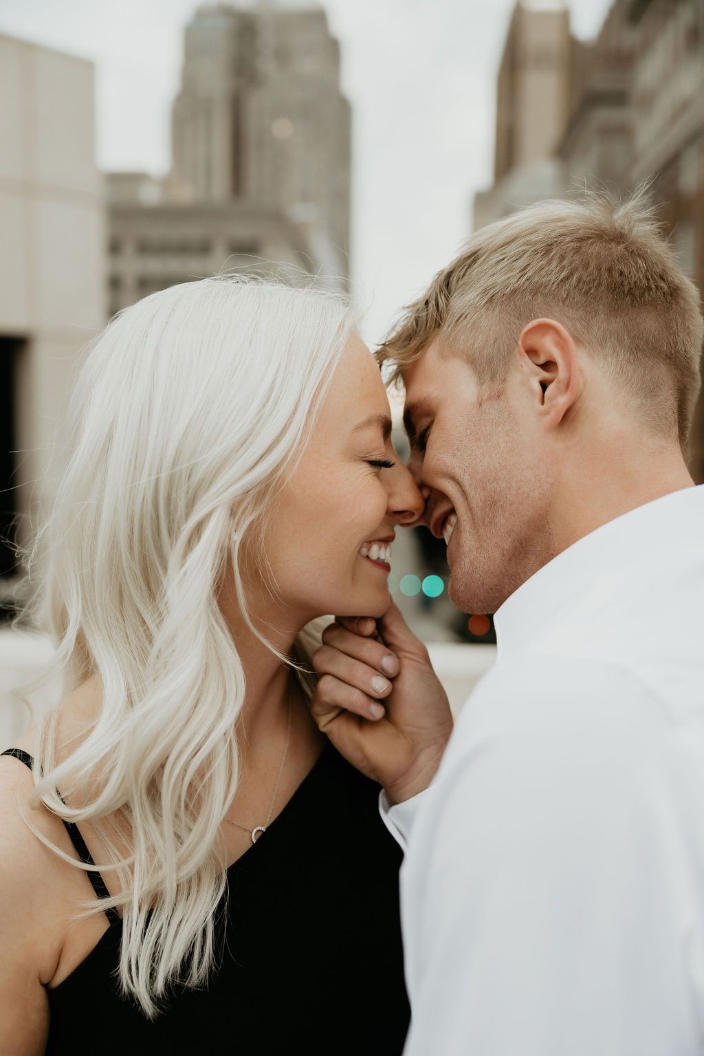 A close-up intimate moment between a couple in black and white clothing.