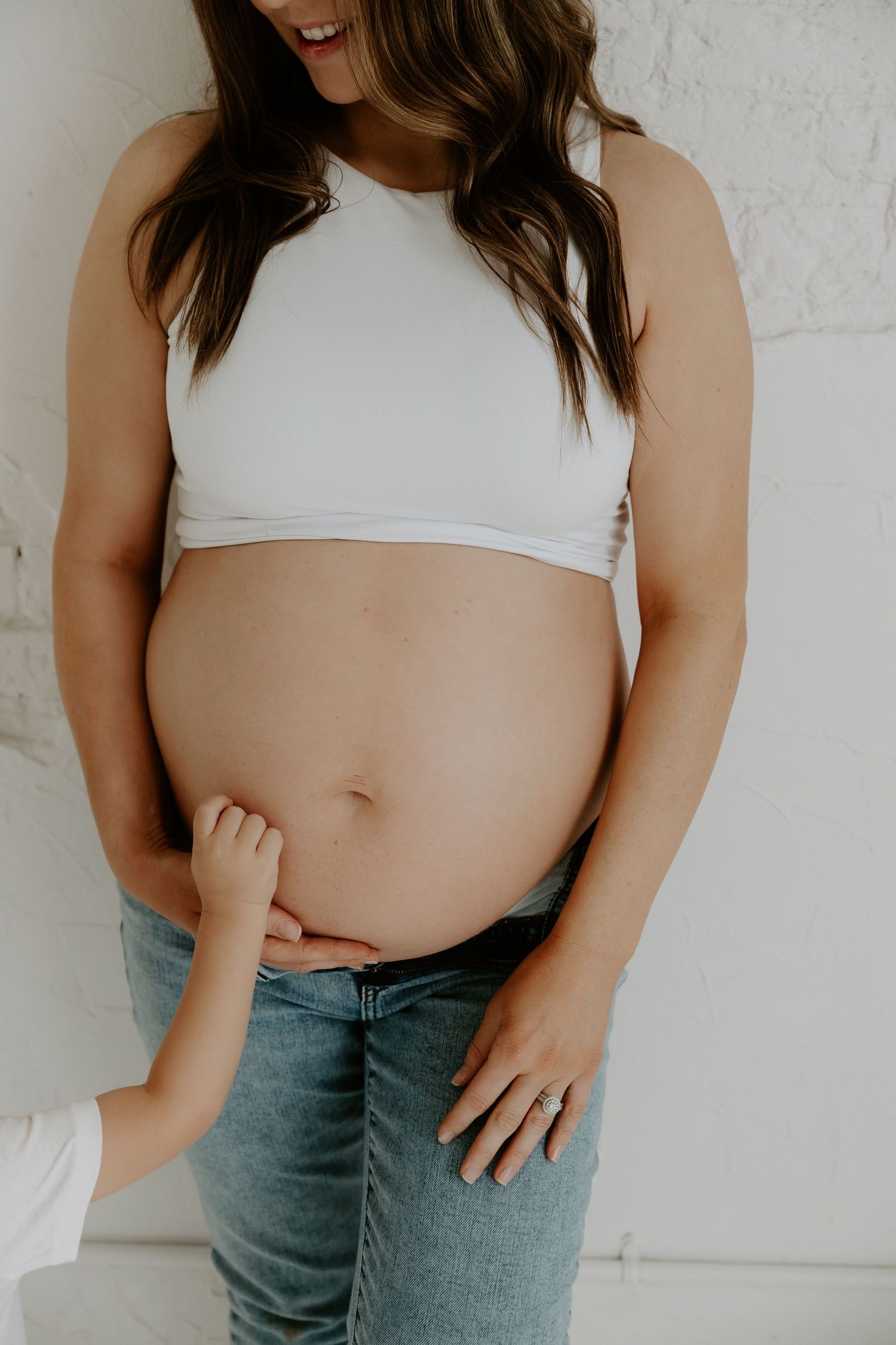 Close-up maternity photography against white background showing pregnancy journey.