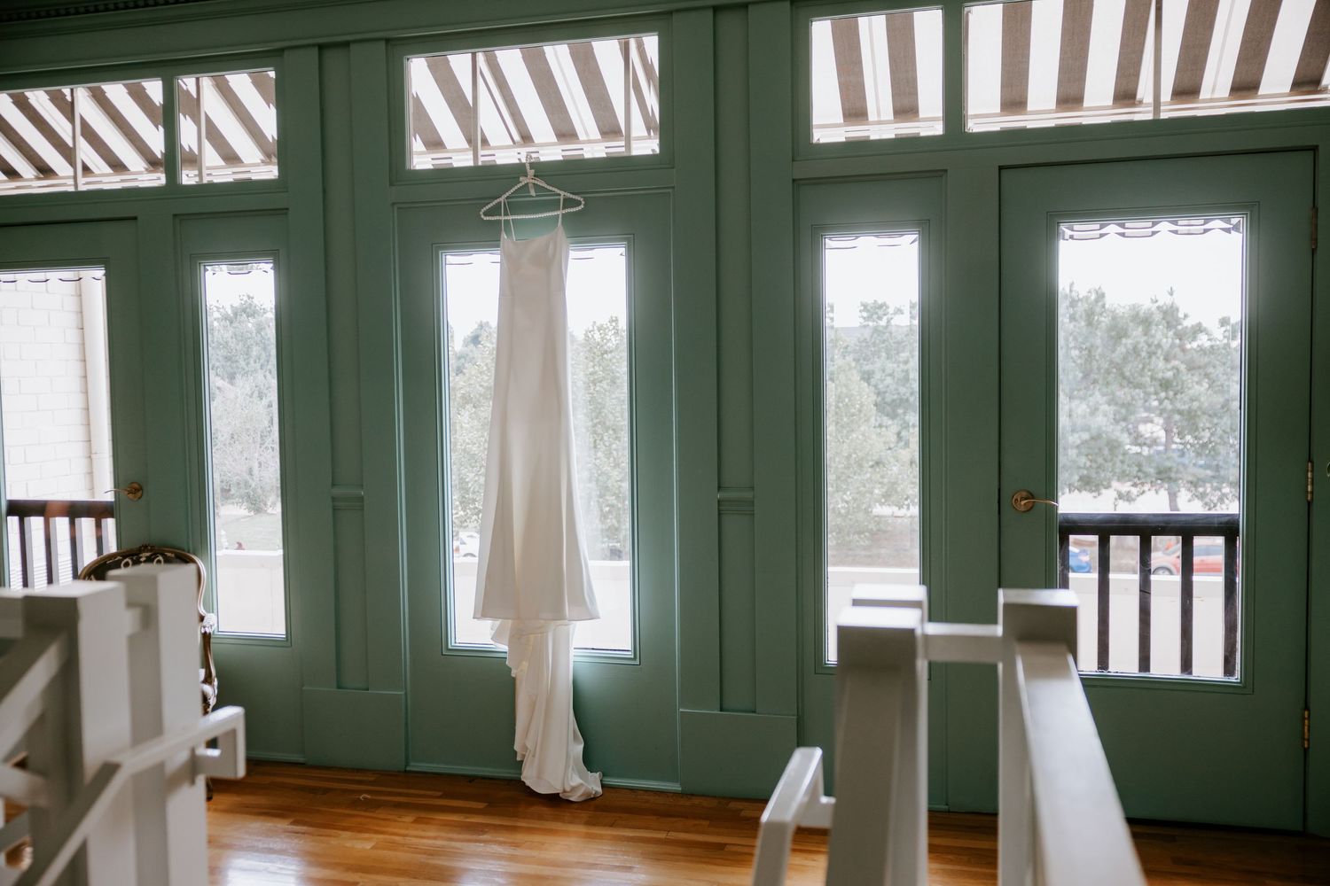 Bright sunlit room with white pillars and striped awning details.