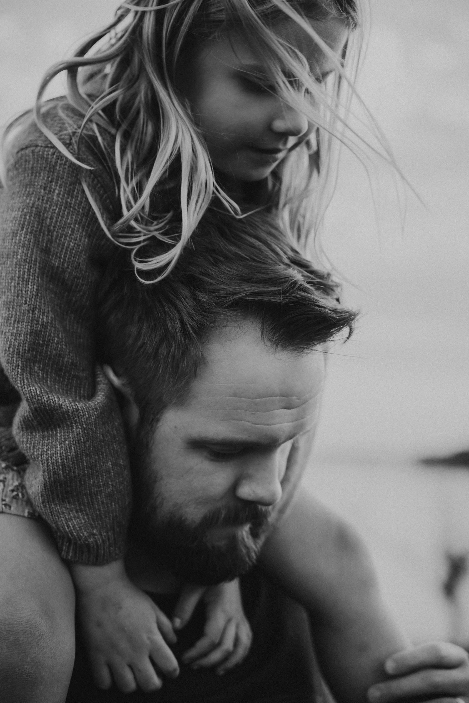 Black and white portrait of intimate family moment outdoors.