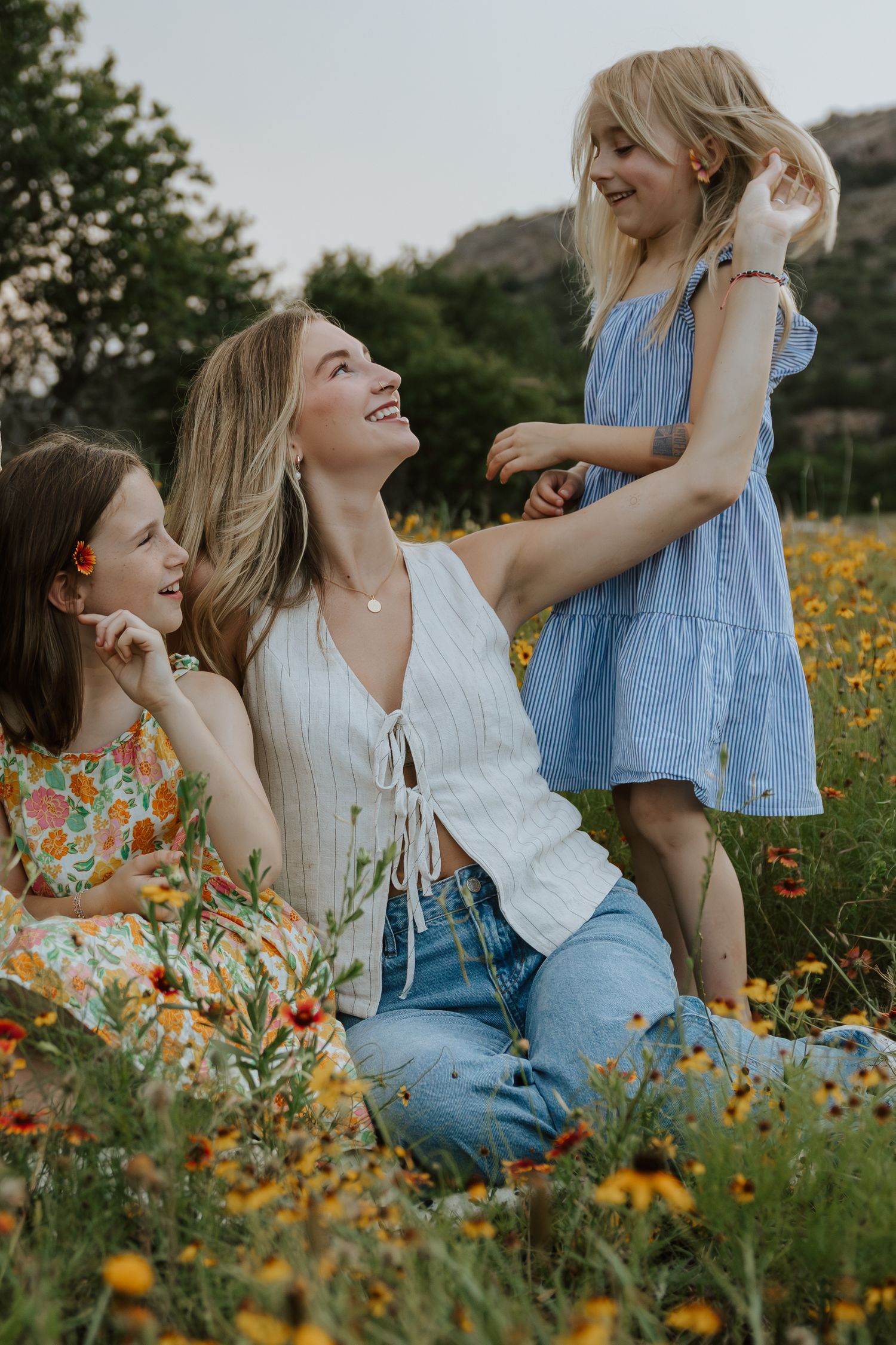 Candid moments of laughter in a wildflower field during sunset photoshoot.