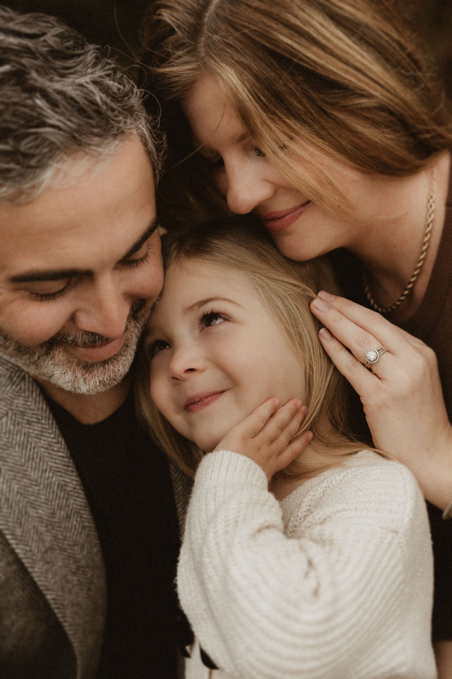 Intimate family moment captured in warm, cozy sweaters.