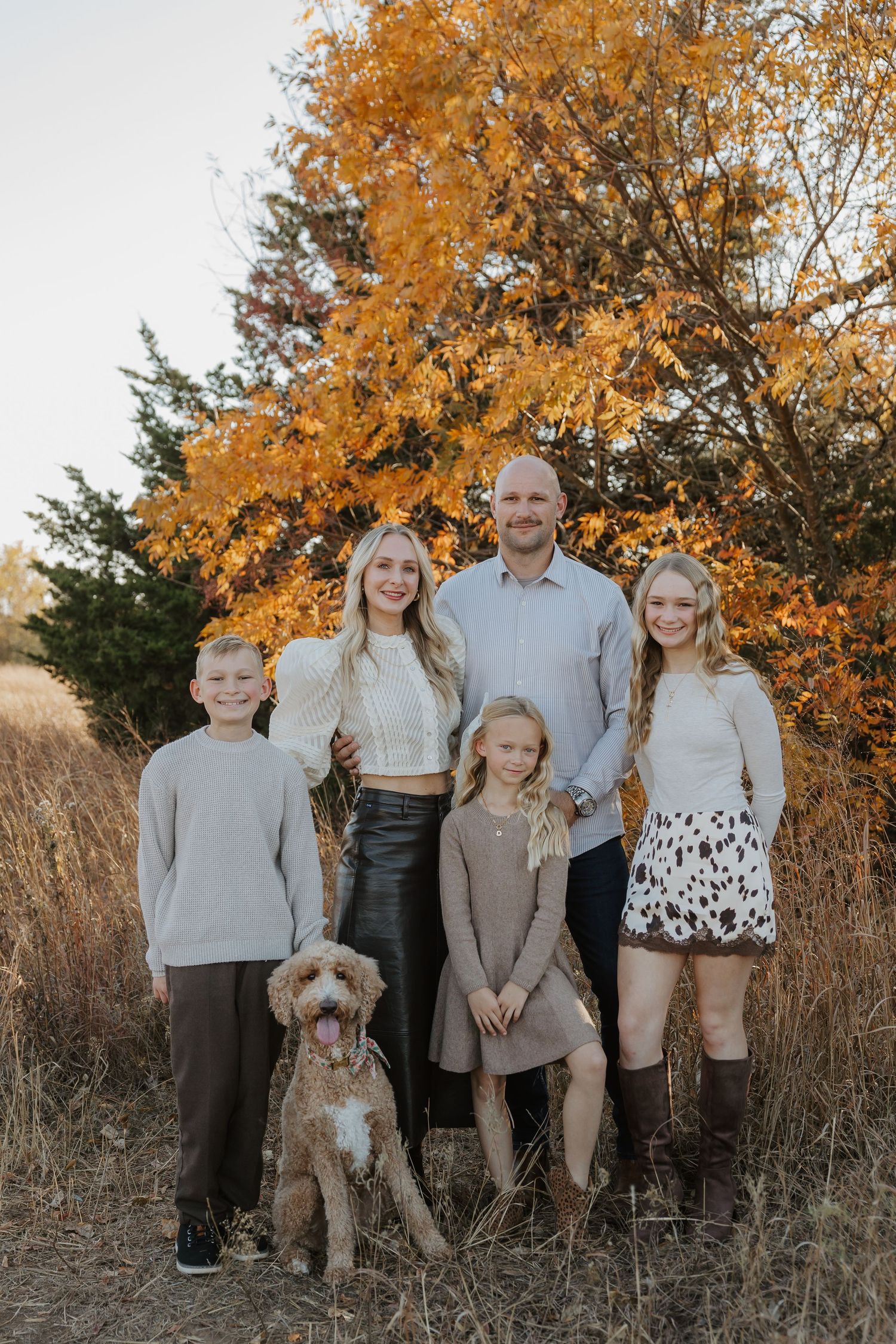 Family group photos in coordinated neutral outfits against autumn foliage backdrop.