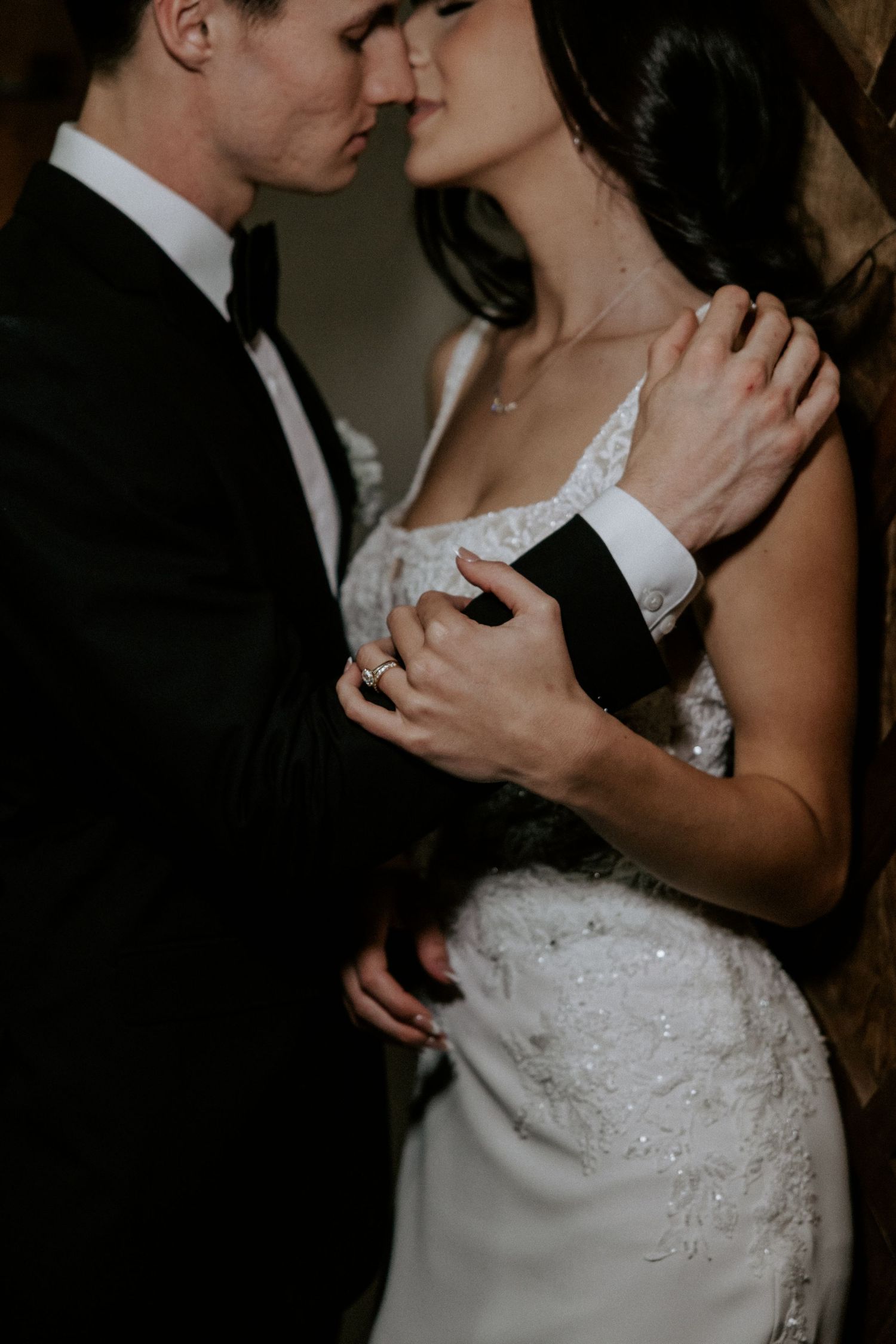 Dramatic wedding portraits showing intimate moments between couple in dark, moody lighting.