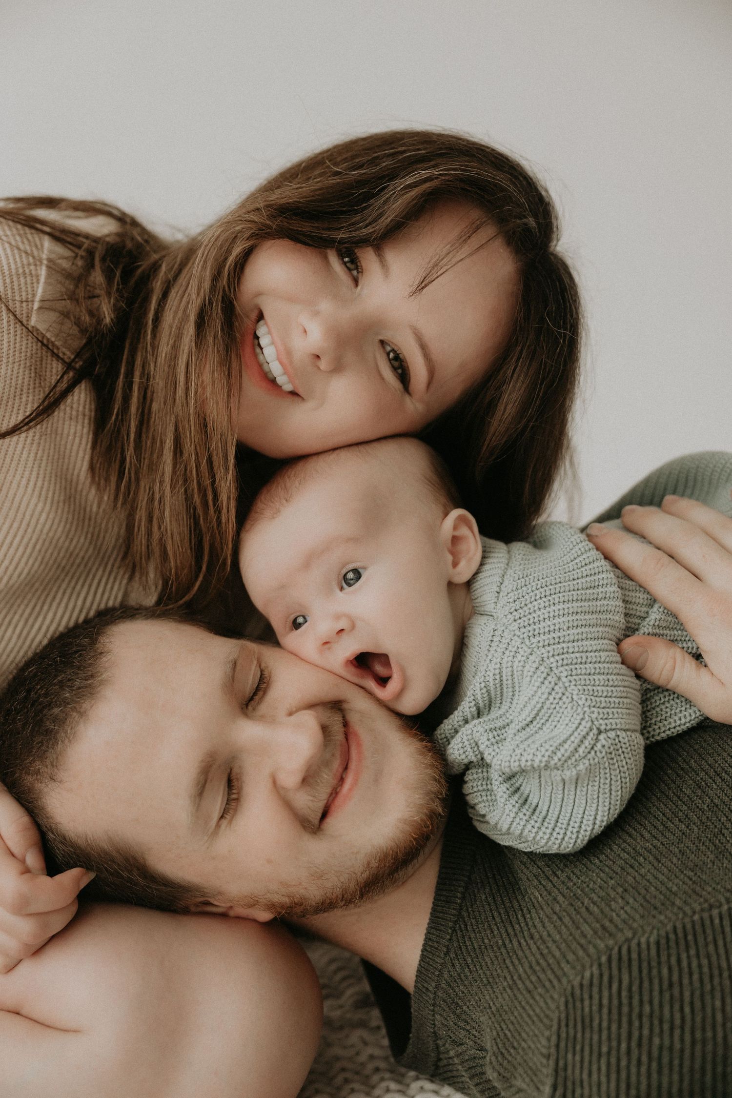Intimate lifestyle portrait session with couple in cozy sweaters against neutral background.