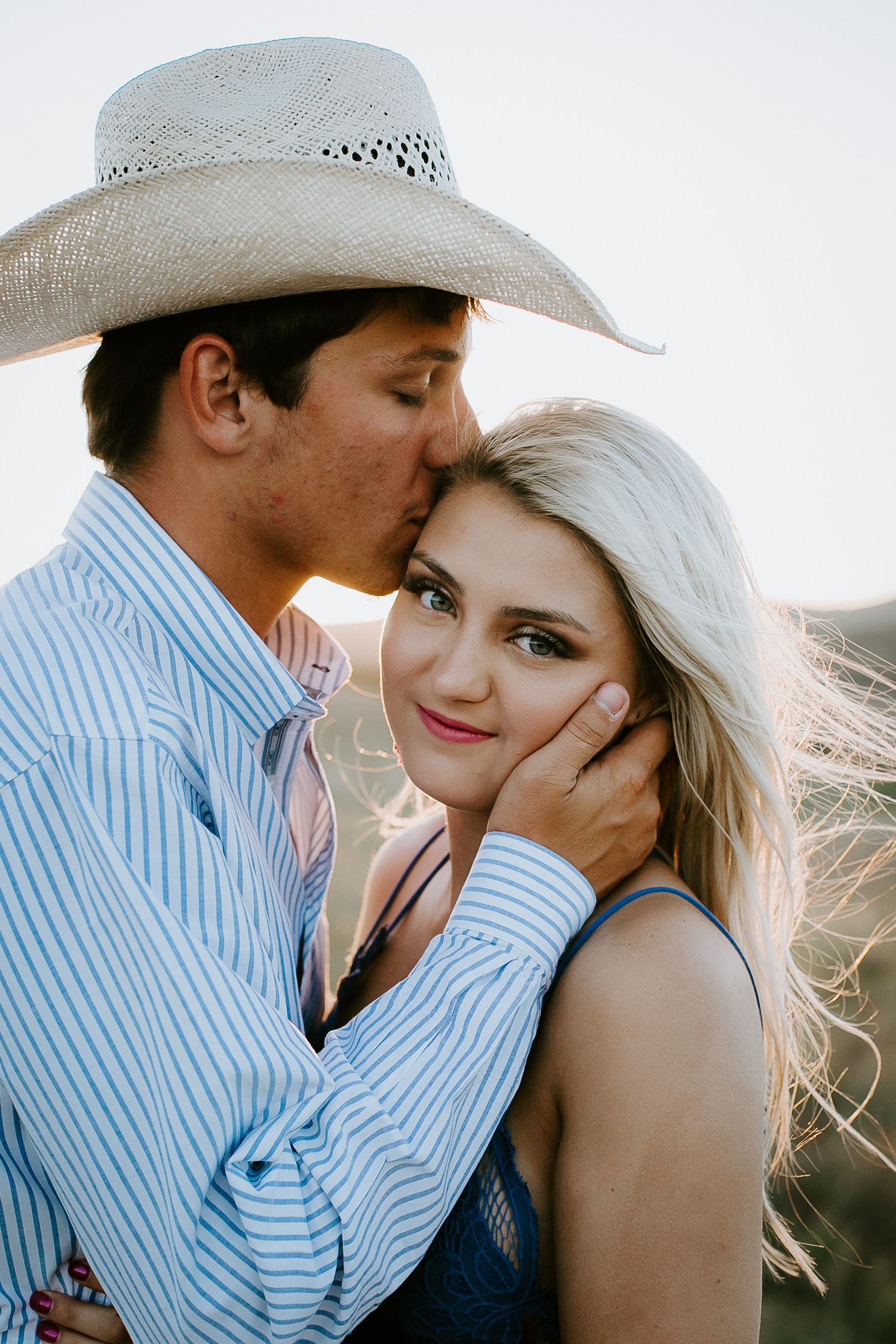 Romantic couple in country western style clothing sharing intimate moments.