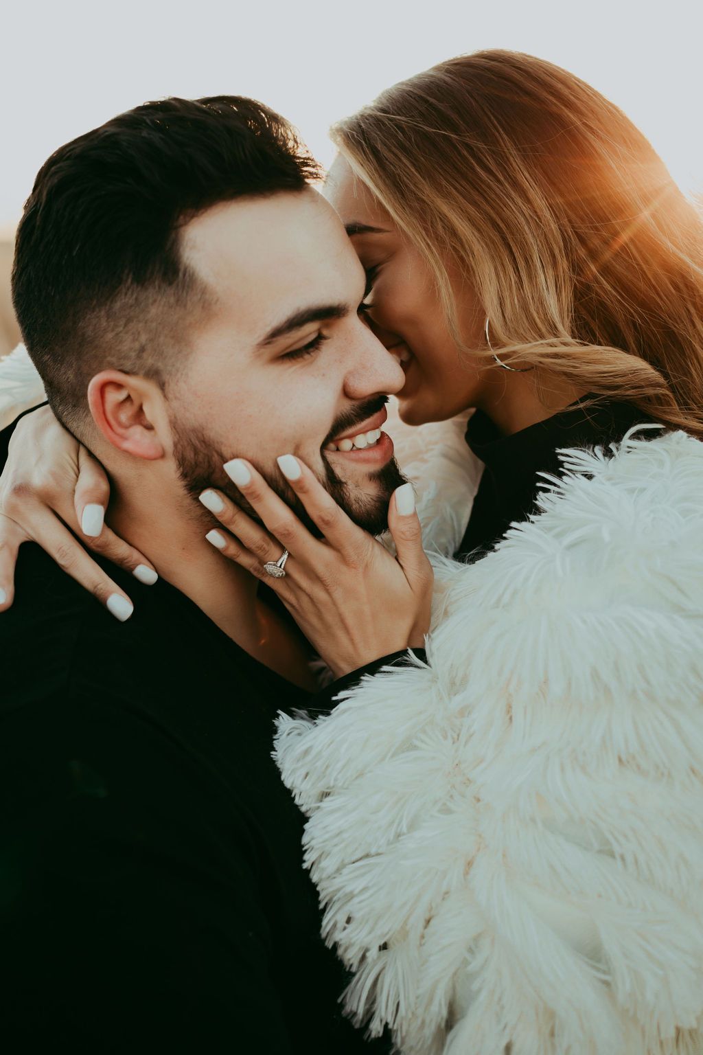 Romantic couple sharing tender moment in warm sunset lighting.