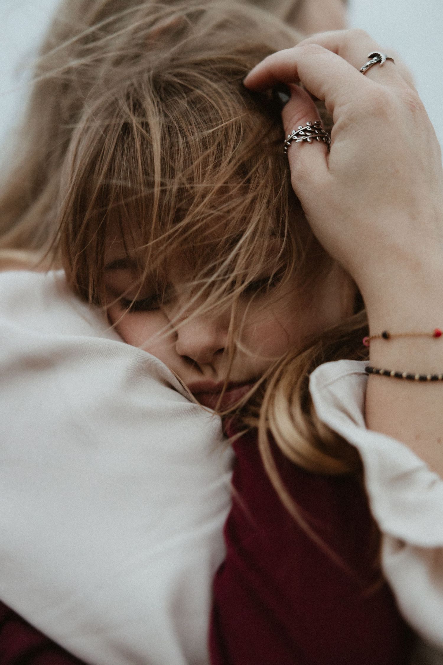 Close-up of gentle hands caressing hair in muted tones.