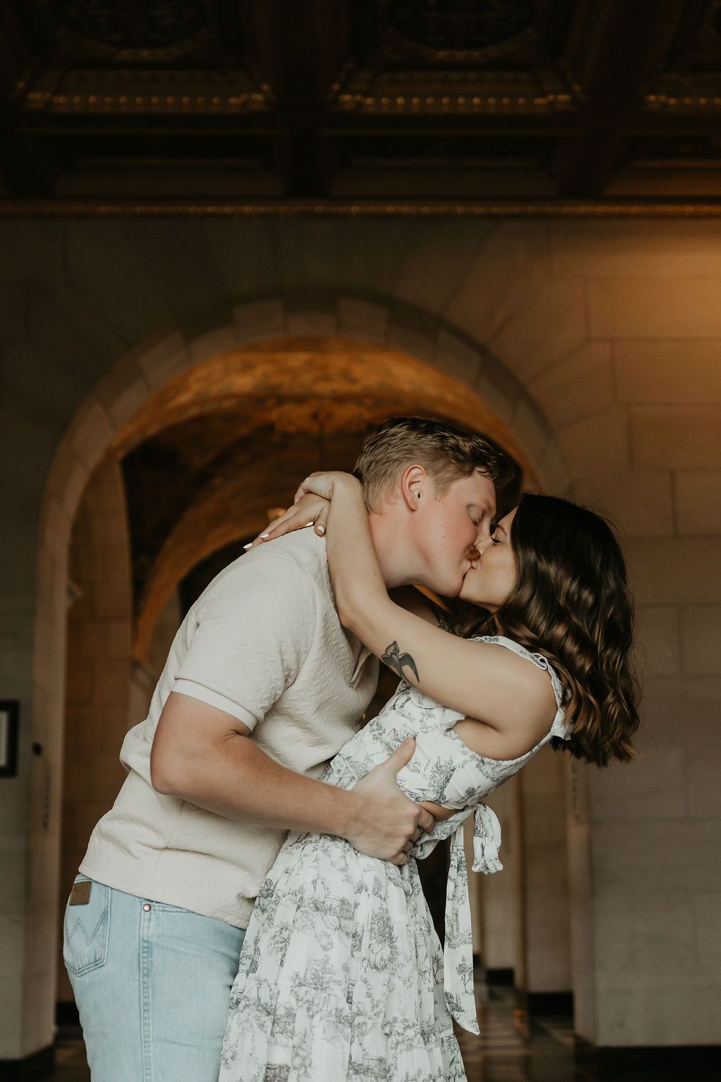 Romantic couple embracing in vintage architectural setting with arched details.