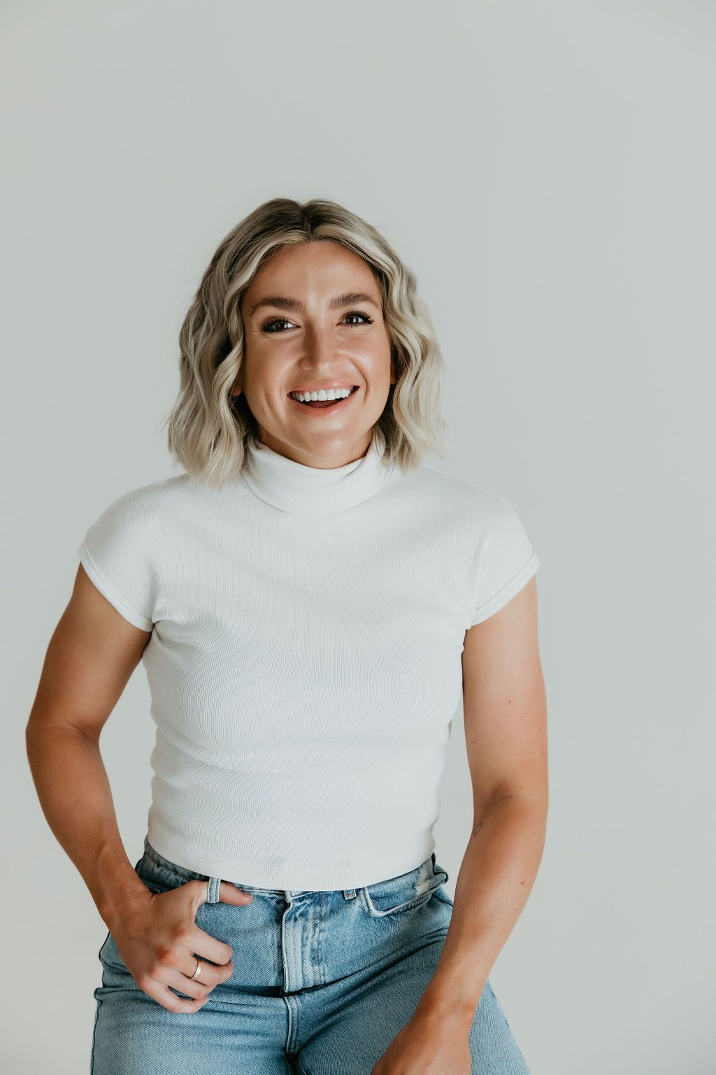 Casual style portraits in white top and jeans against light background.