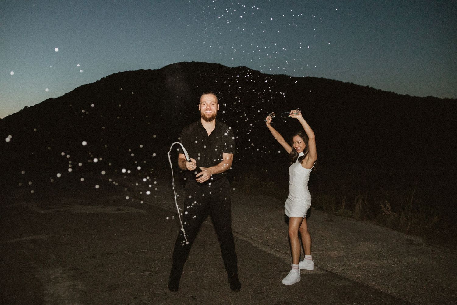 Couple dancing under starlit sky, creating dynamic movements in evening light.