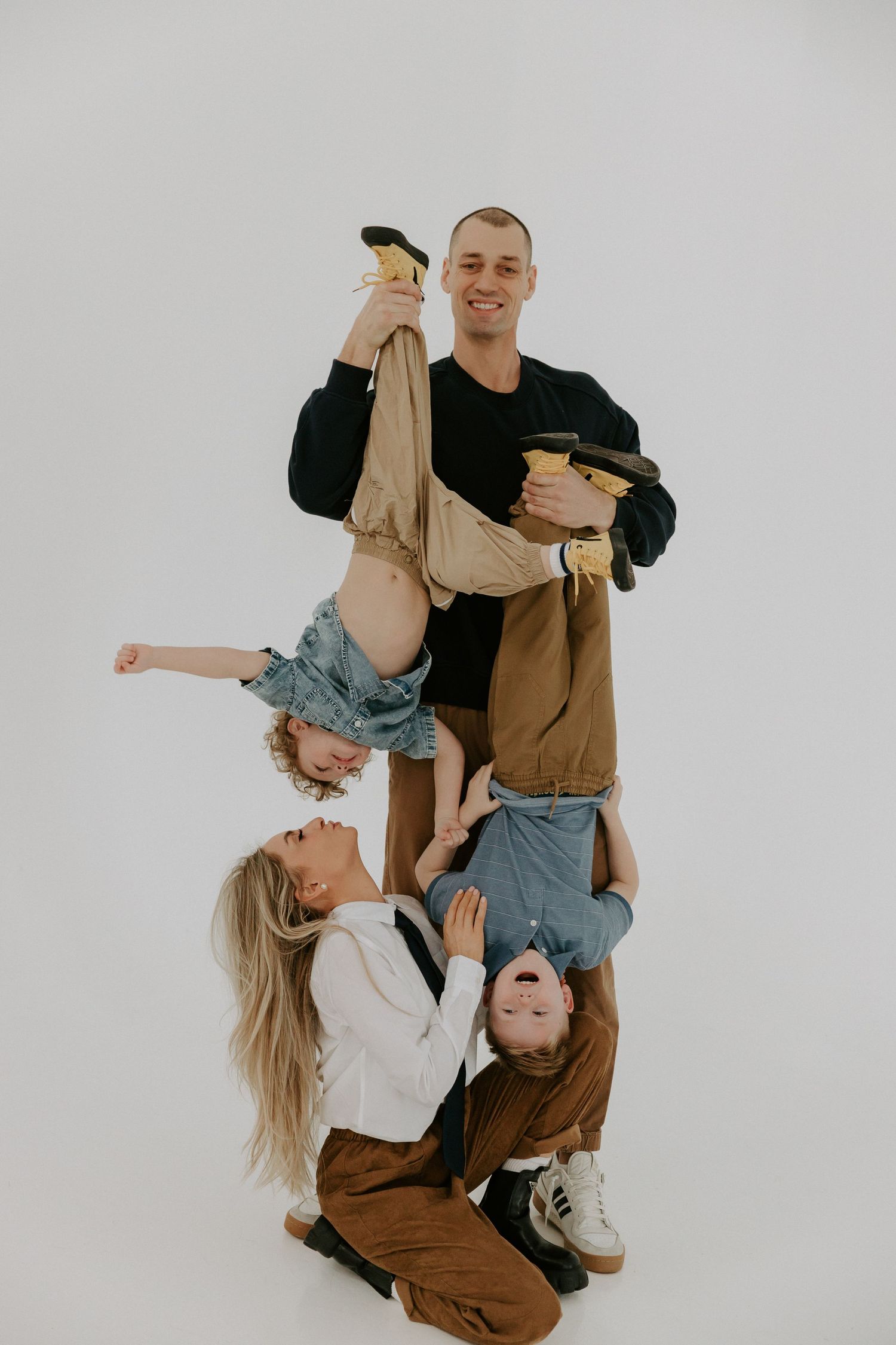 Playful dance-like poses captured against white background showing movement and connection between two people.