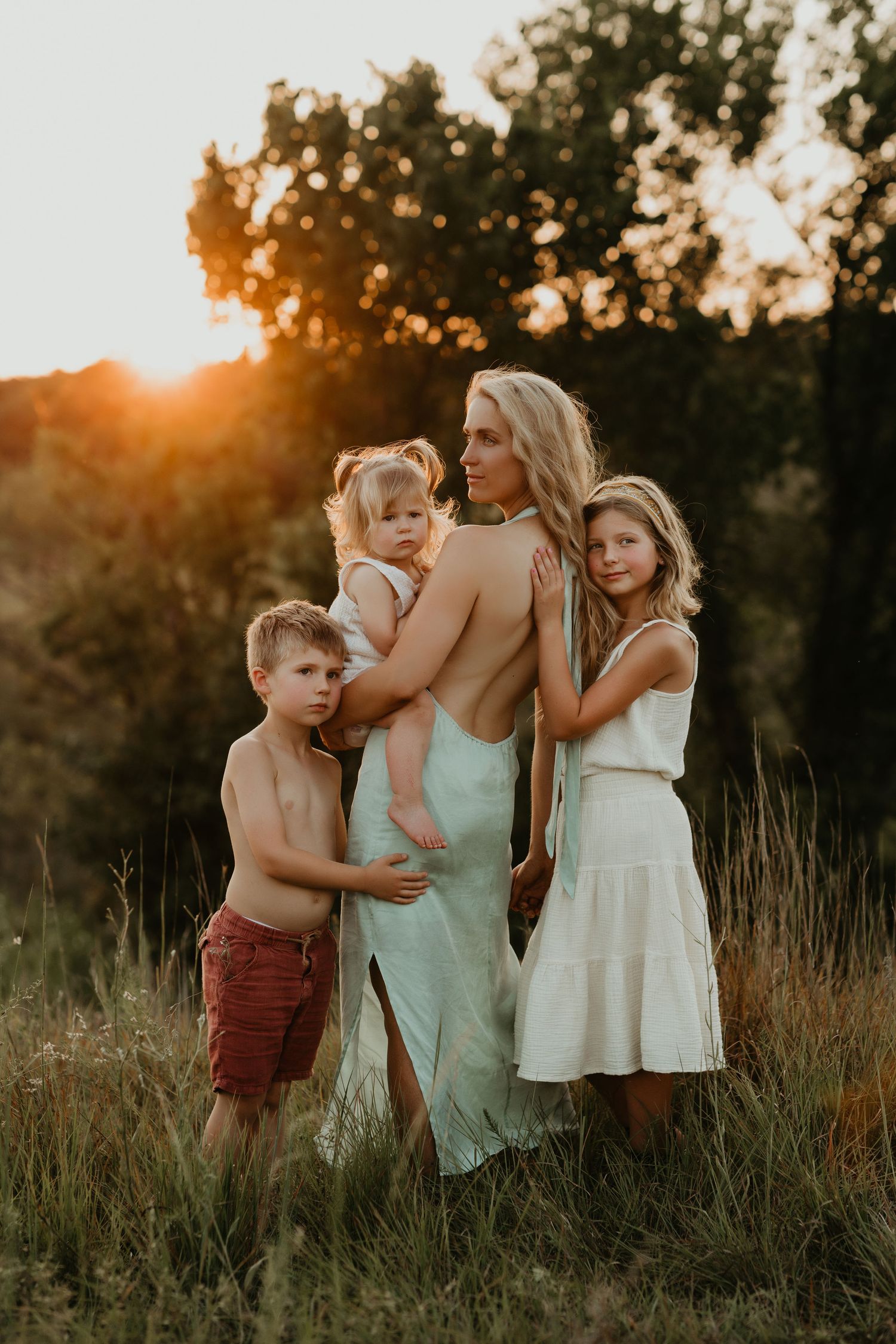 A sunset photoshoot in a golden field with light summer outfits.