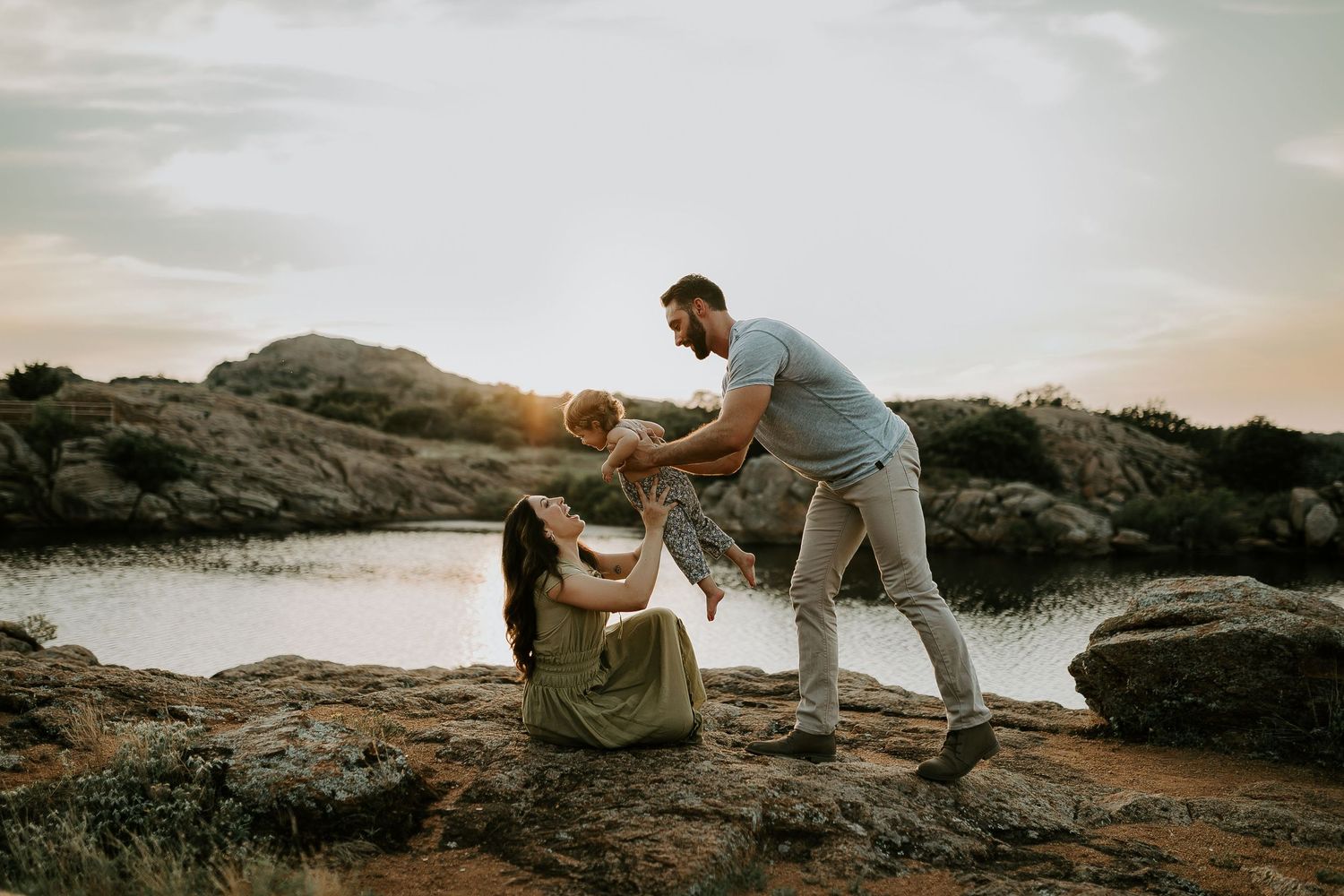 People exploring rocky terrain against a scenic sunset backdrop.