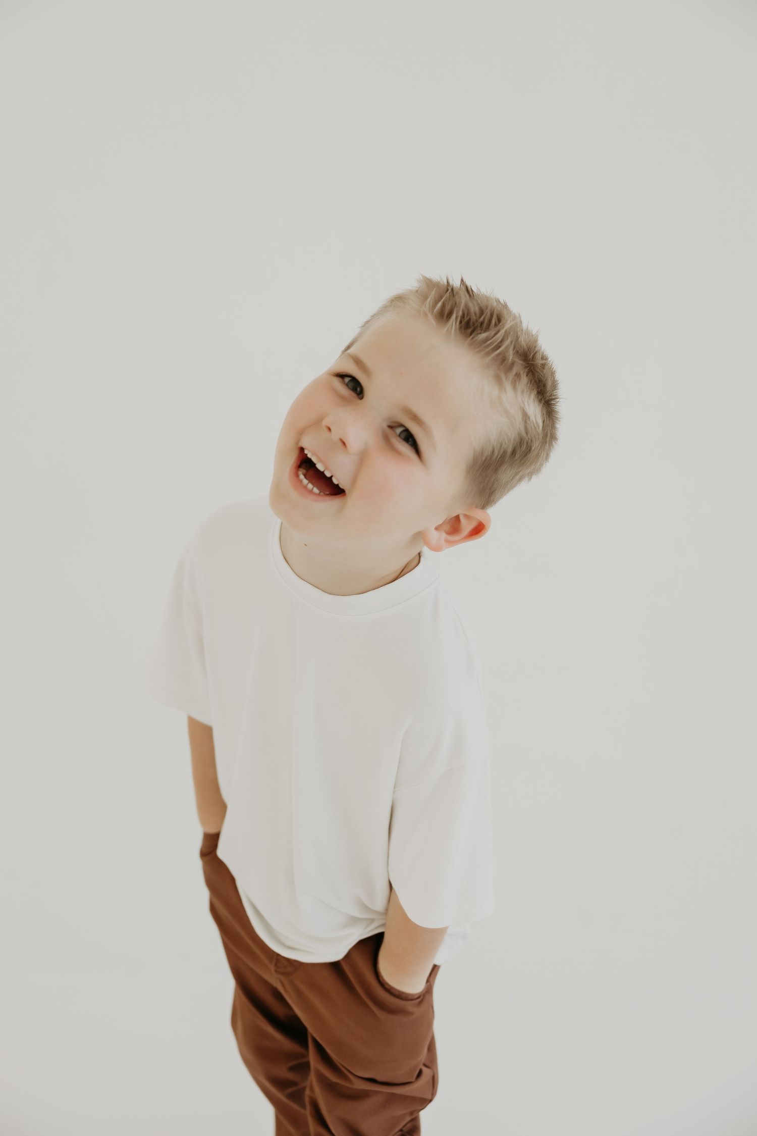 Joyful expressions captured in white studio setting with playful poses.