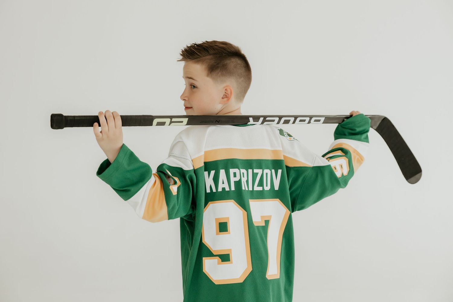 Person displaying green hockey jersey with number 97.