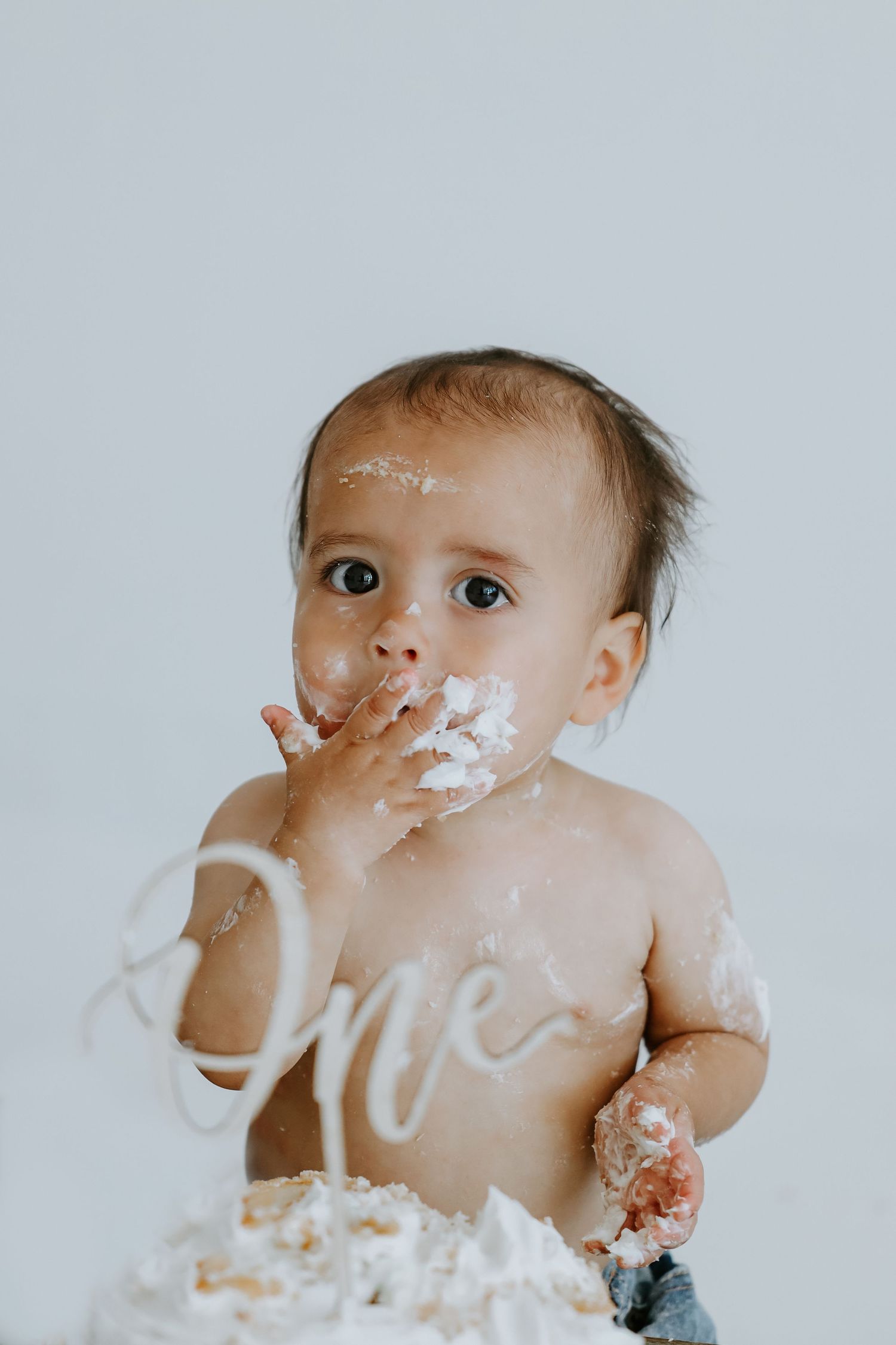 Cake smash photo series showing messy first birthday celebration.