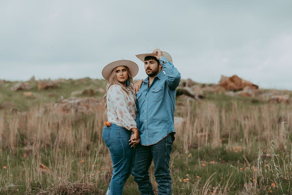 Couple walking through rustic field during countryside photoshoot.