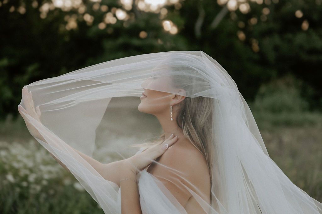 Dramatic bridal portraits with flowing veil in natural light.