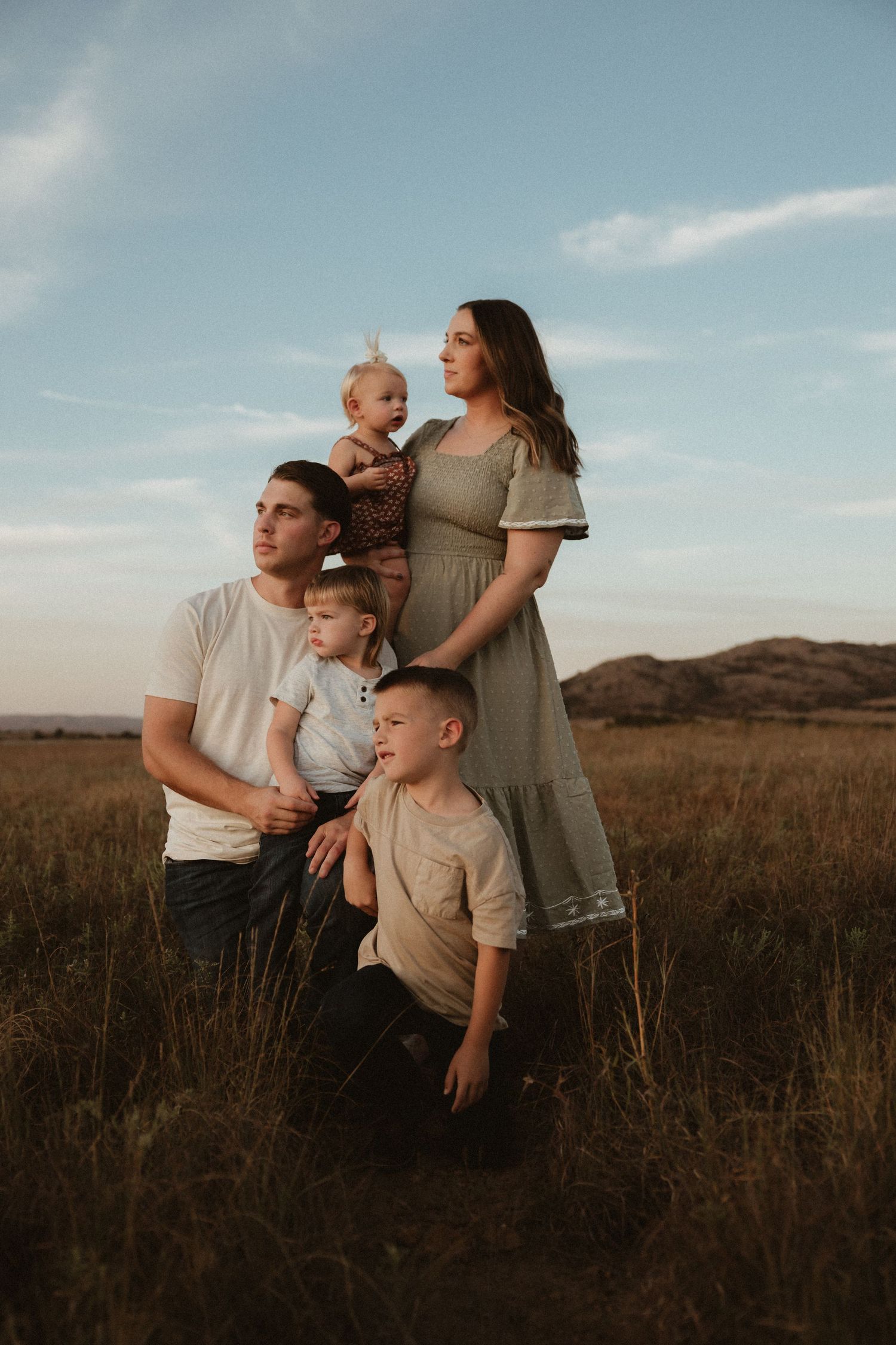 Family enjoying quality time together in a scenic field during golden hour.