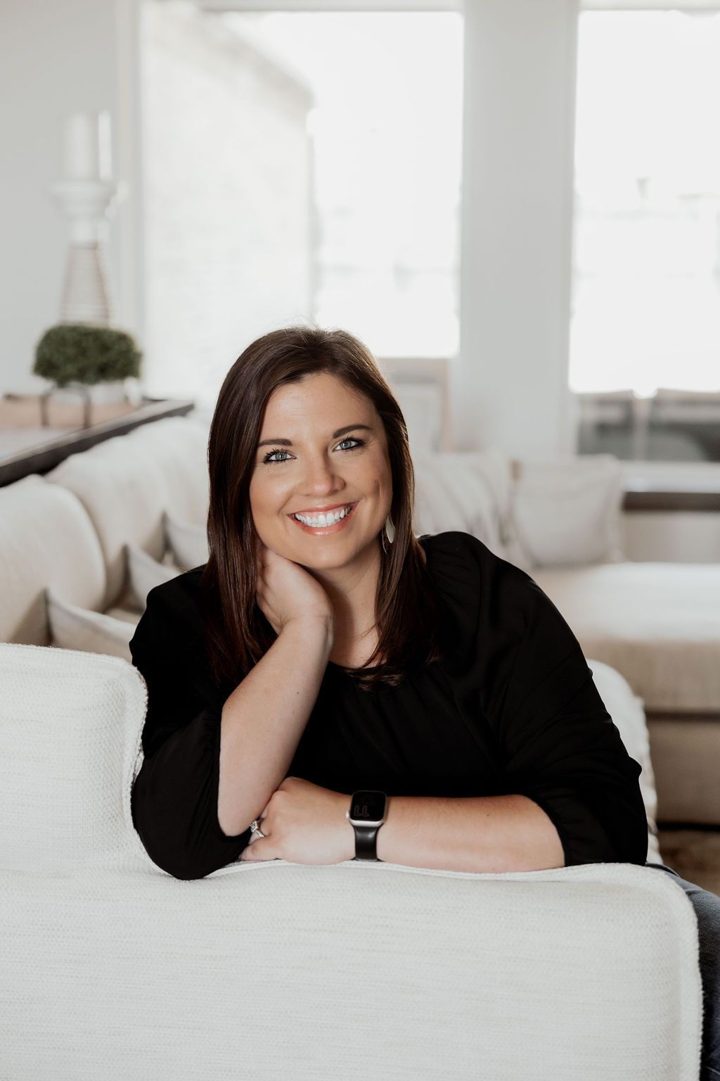 Relaxed portrait session on white furniture in bright interior setting.