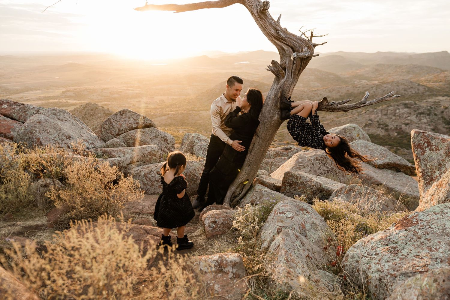 Series of silhouettes against a sunset sky on rocky mountain terrain.