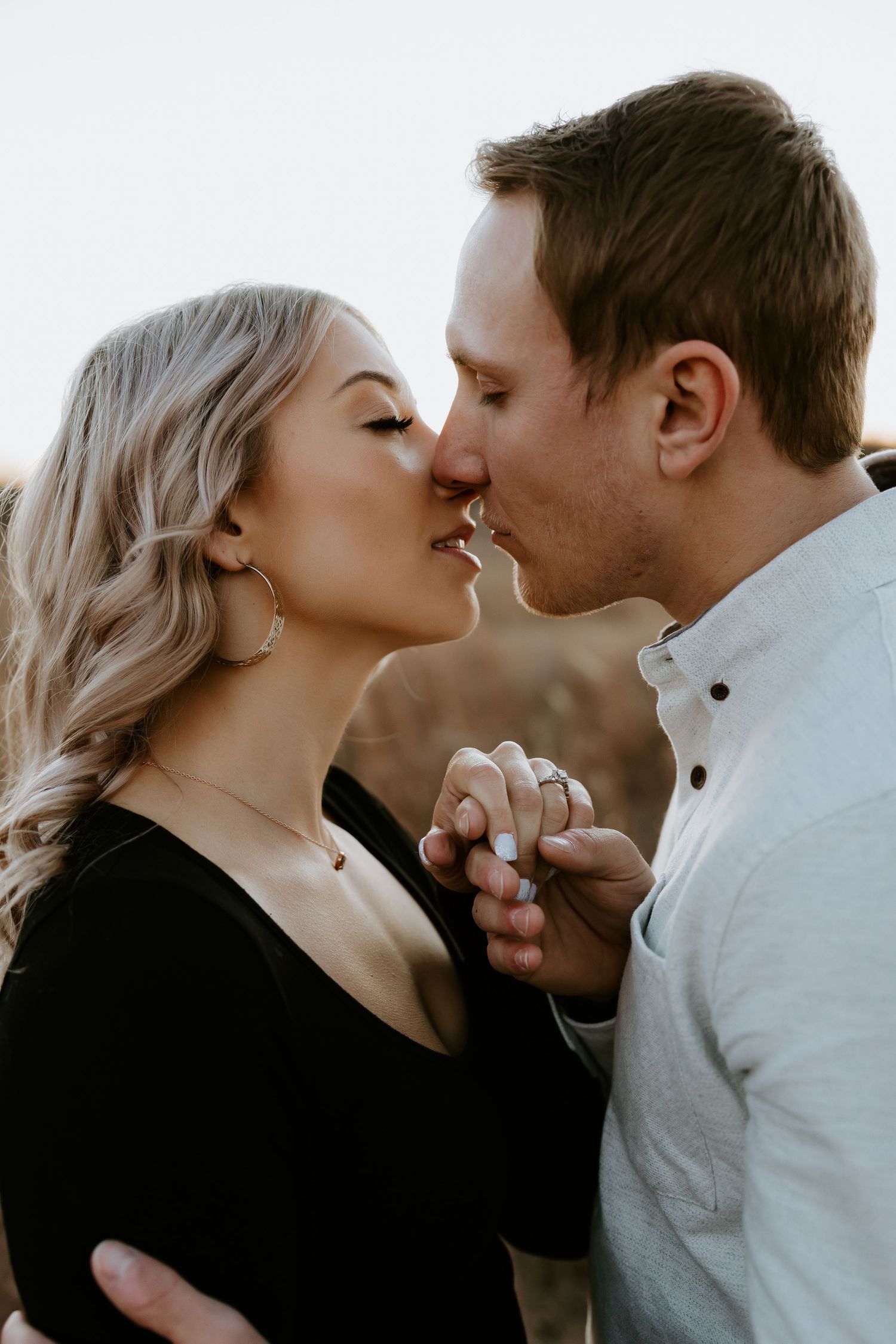 An intimate close-up of a couple sharing a tender moment outdoors.