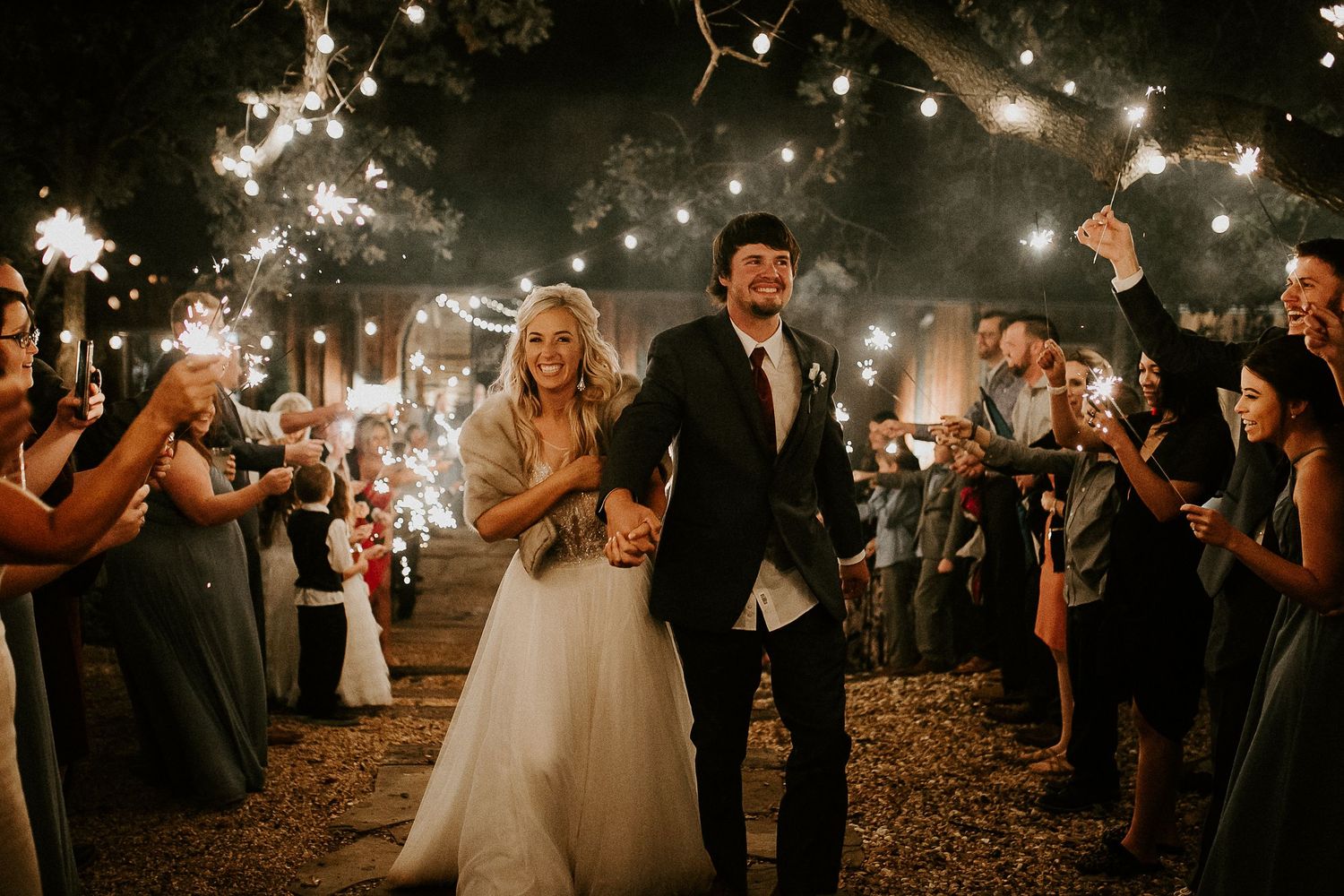 Wedding celebration at night with string lights and dancing.