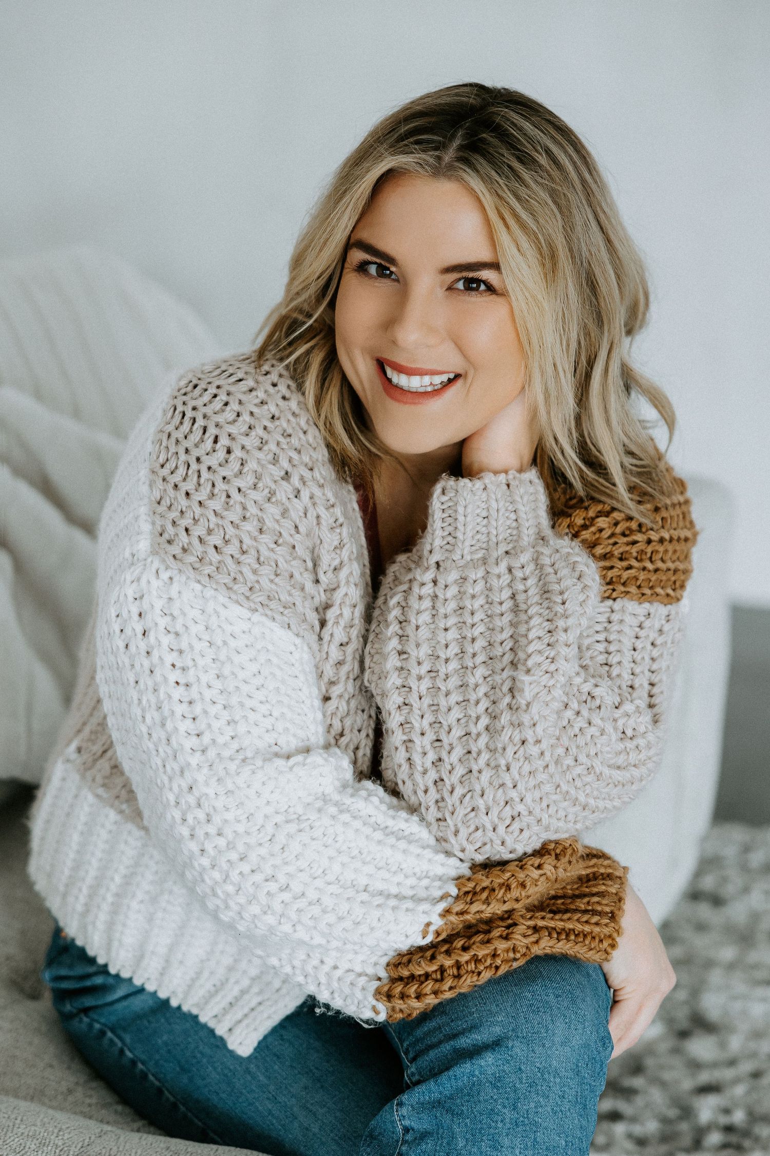 Portrait series in cozy chunky knit sweater and denim against light background.