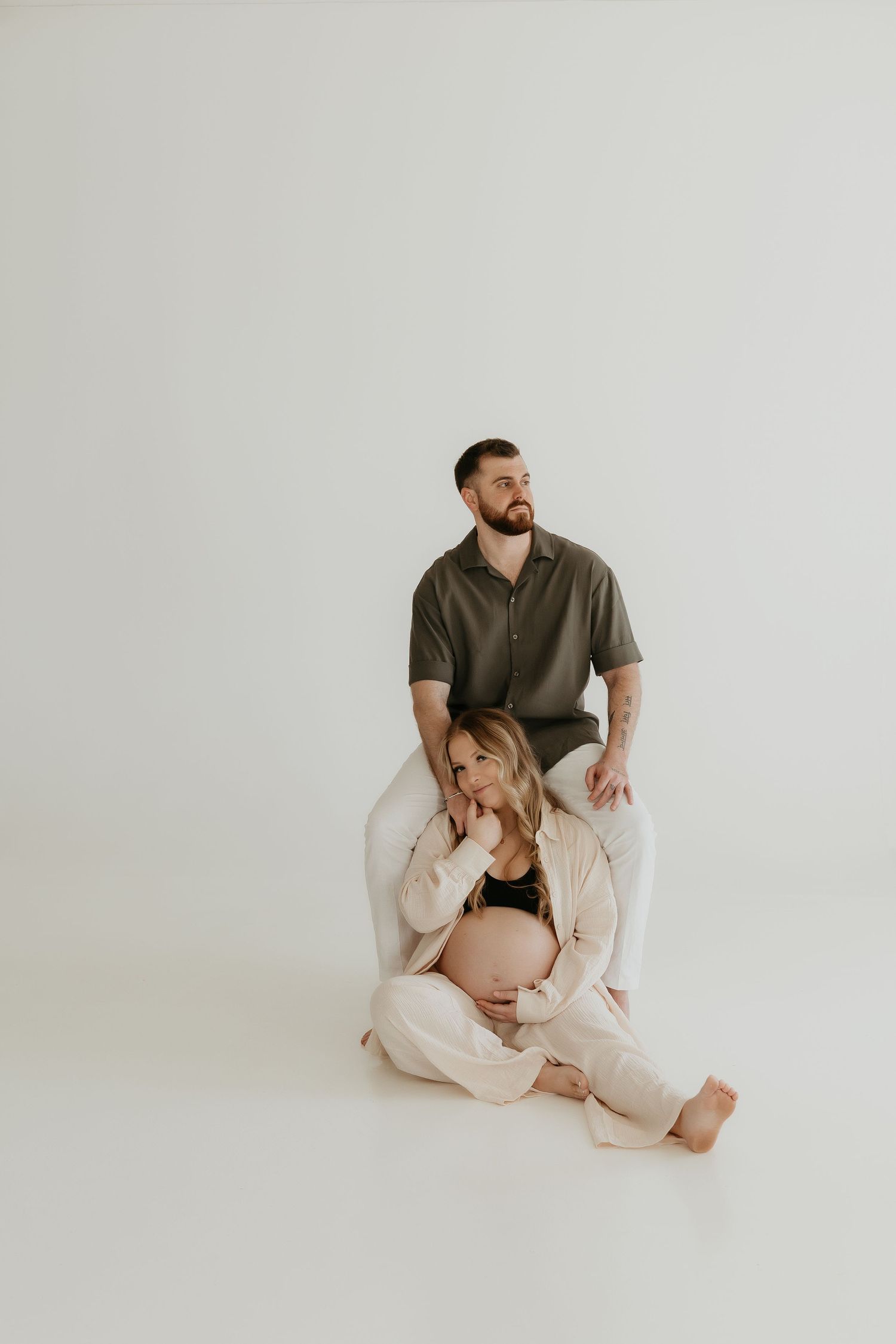 Artistic maternity studio photos in neutral tones showing intimate poses.