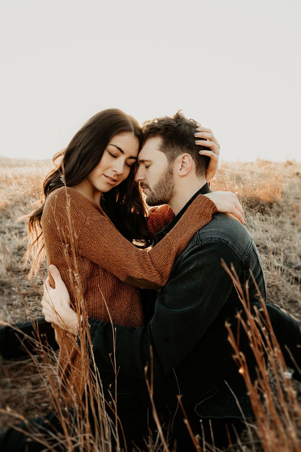 Tender moments between couple in autumn field, sharing intimate embraces at sunset.