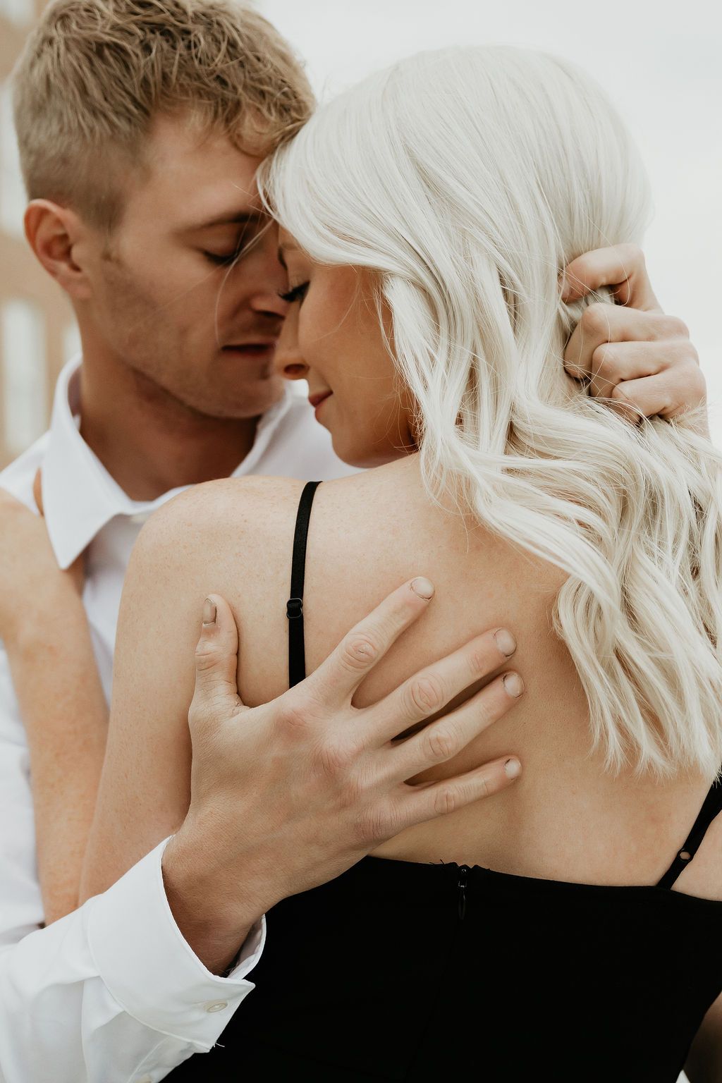 Close-up of intimate couple sharing tender moments in natural light.